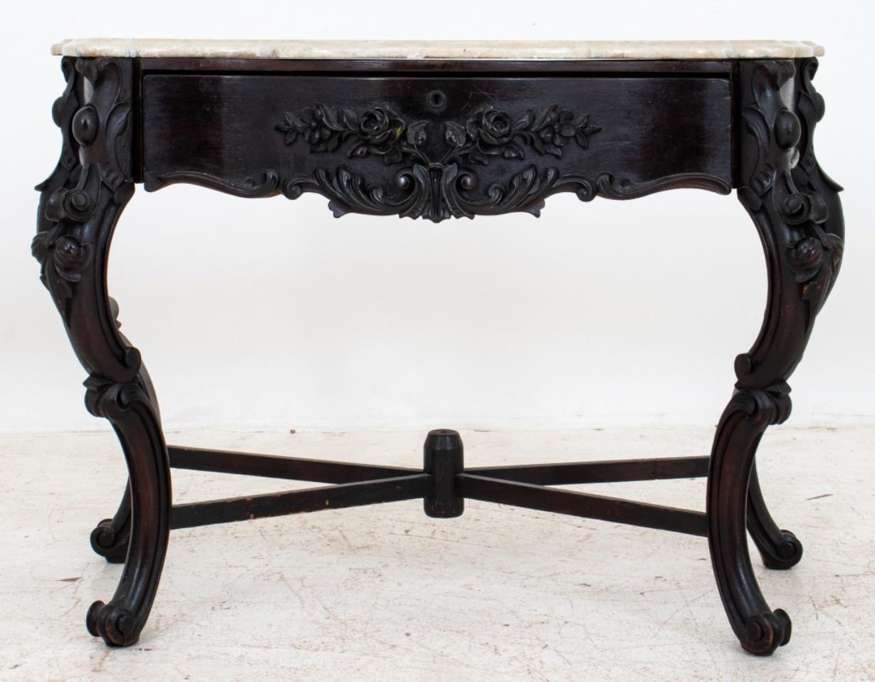 Victorian dark mahogany console with carrara marble top, with serpentine shaped front and sides above floral carved cabriole legs joined by a x-stretchers, one drawer with three compartments, restorations and scratches on marble, likely late 19th