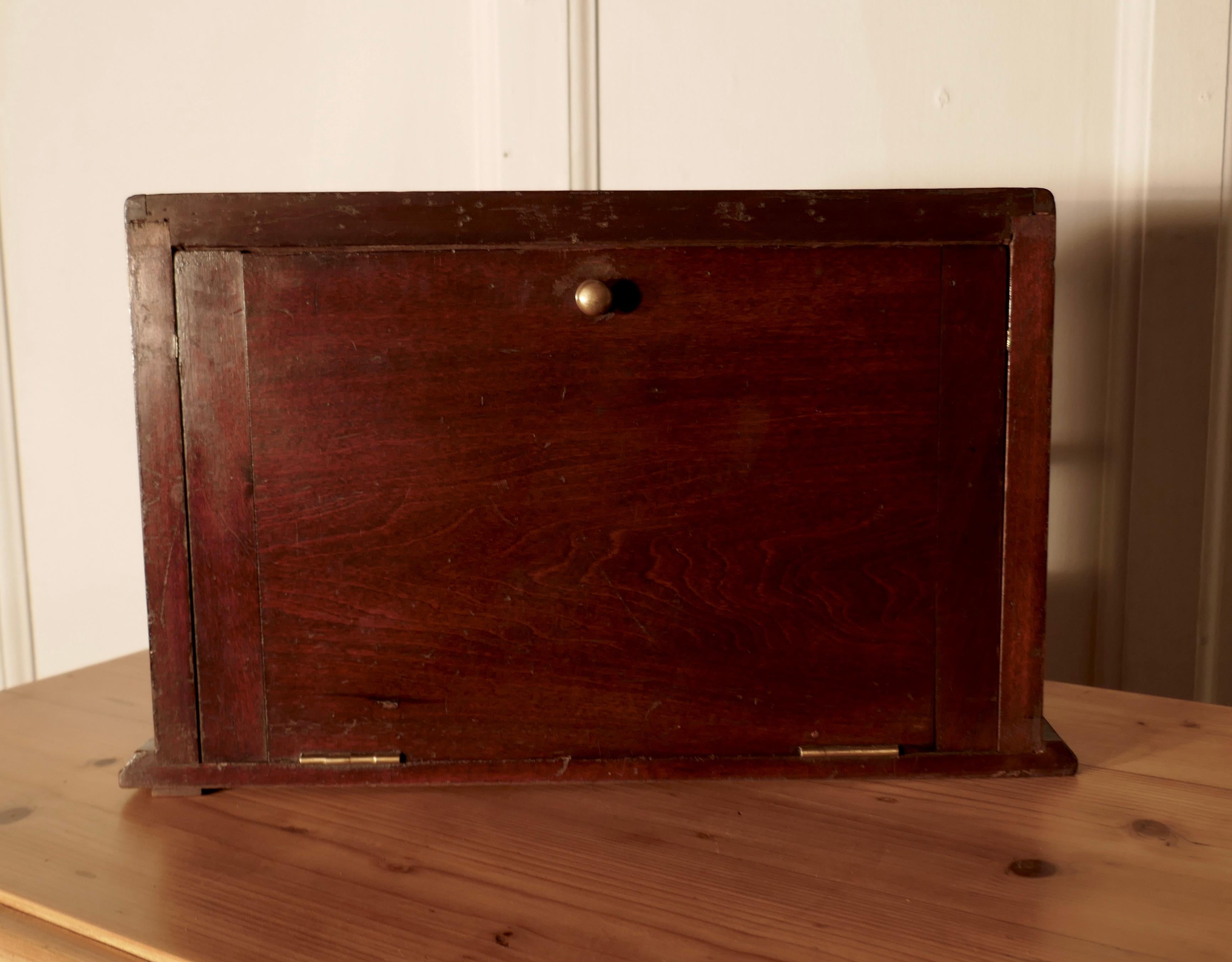 Victorian mahogany counter top jewelry display cabinet

A charming piece, this is a small counter top cabinet, it slopes at the top and has glass all the way around, access is by a drop door at the back, the floor is lined with Red baize 
The