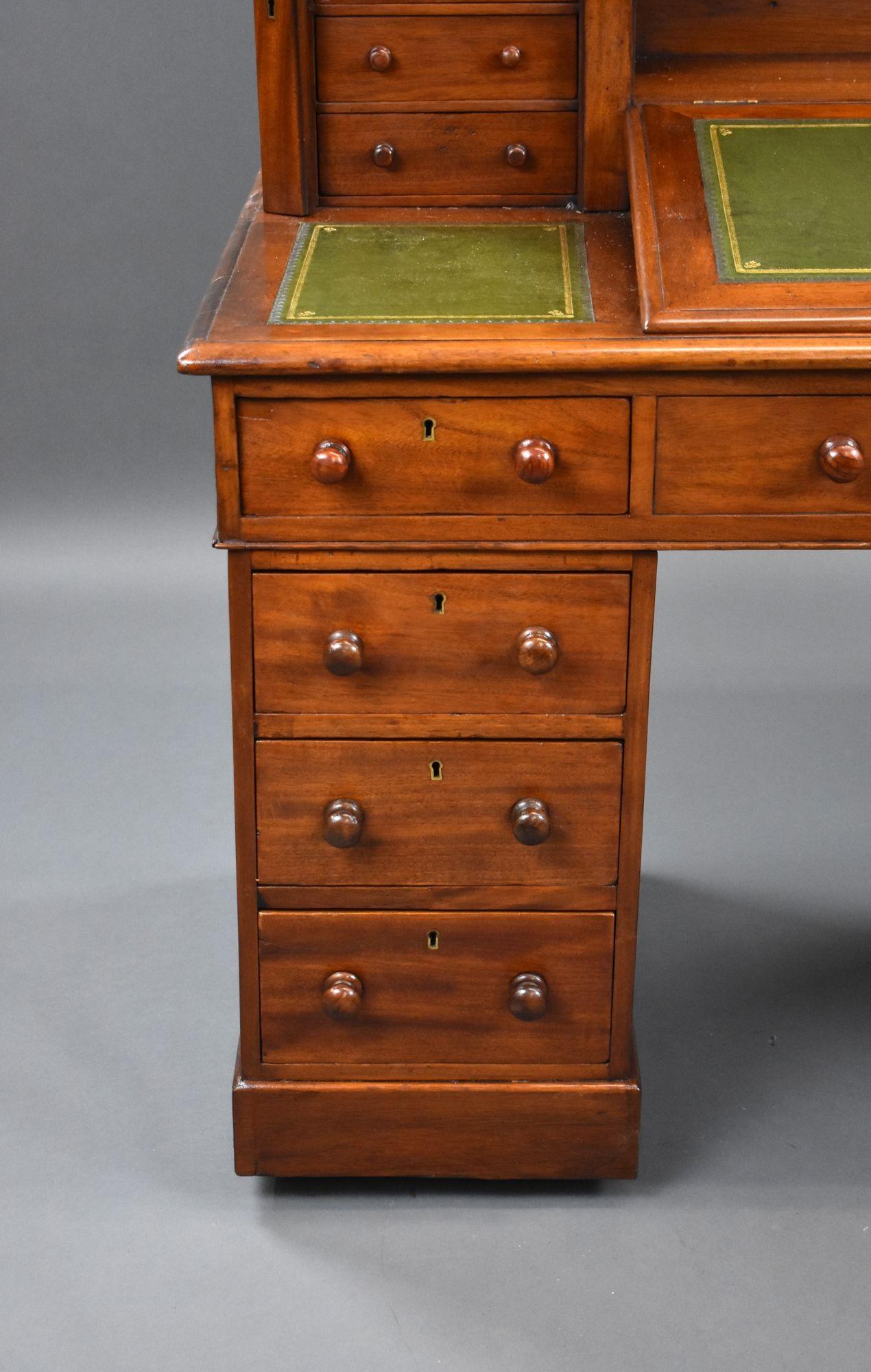 For sale is a Victorian mahogany dickens desk, having four drawers on each side of the top, locked with a side locker, with three green leather inserts and a rising fall in the centre, above a faux drawer flanked by drawers on either side. Each