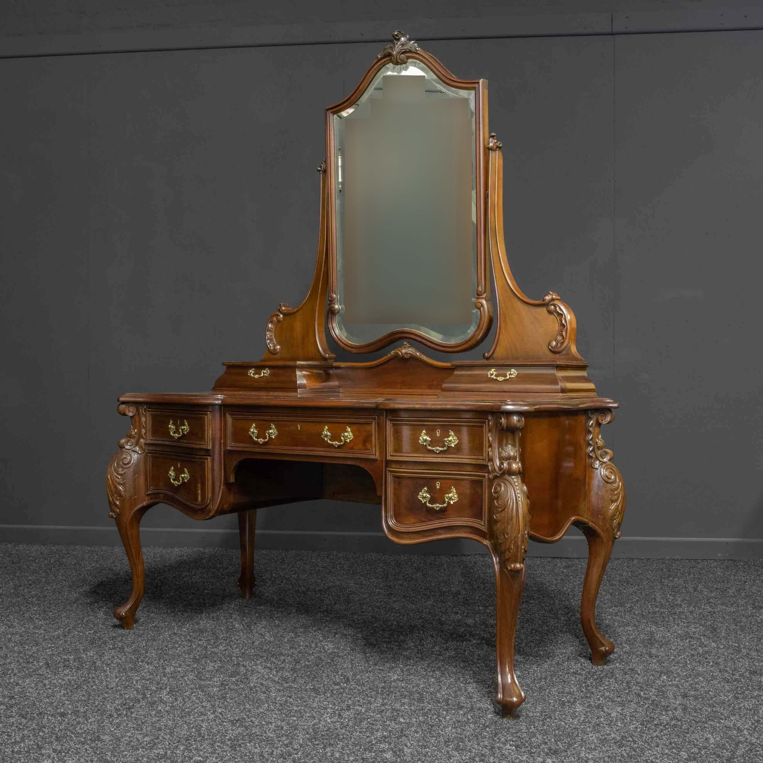 A superb and large Victorian mahogany dressing table of French Rococo design. With bold cabriole legs, richly carved to the shoulders with Acanthus. The front is stepped serpentine in shape with a pair of jewellery drawers either side of the large