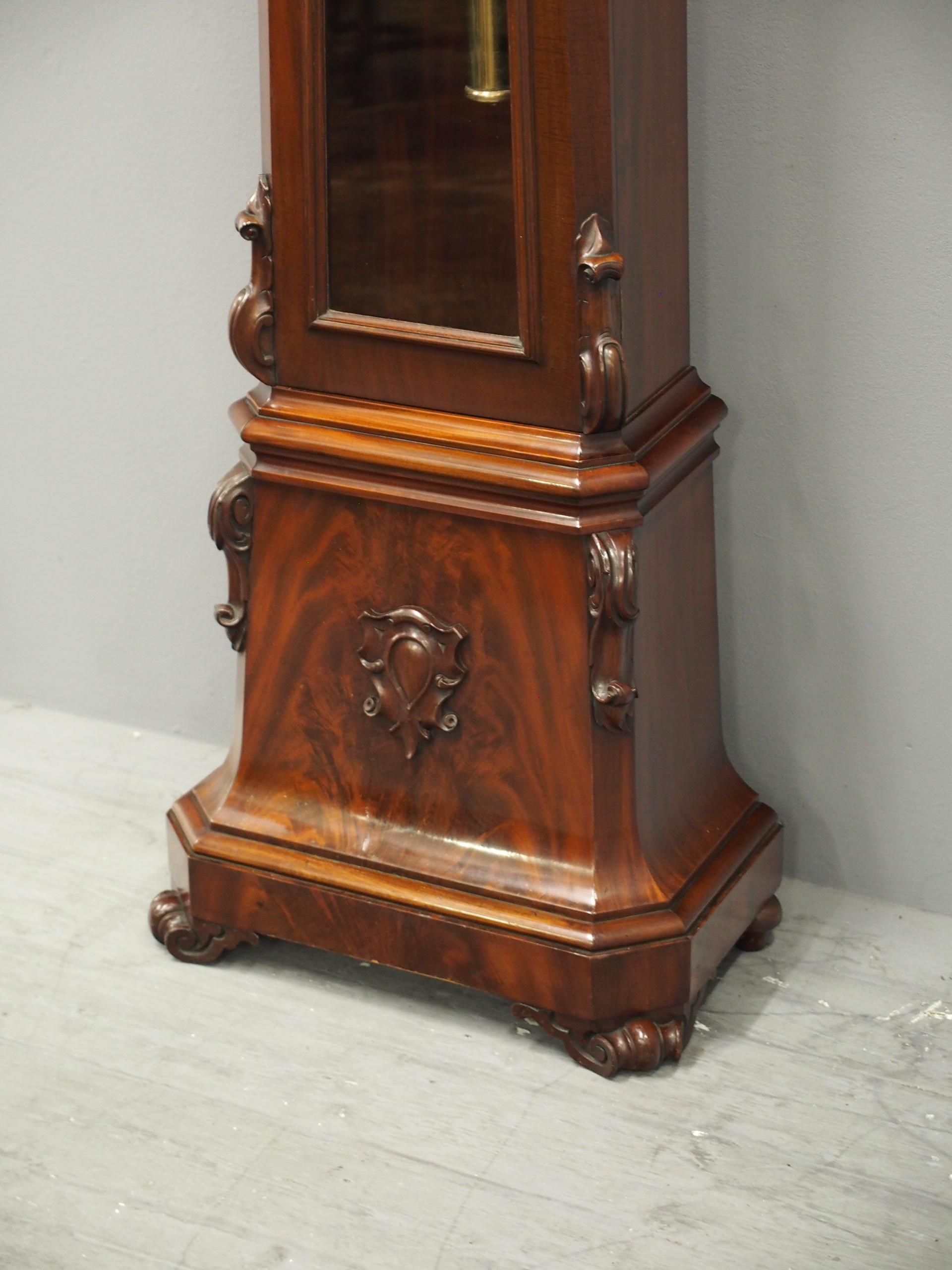 Mid Victorian mahogany dome-top glass fronted grandfather clock by W C Shaw, 64 Argyle Street, Glasgow, circa 1860. With carved foliate and c-scroll designs to the drum head and a brass bezel containing a silvered face with Roman numerals. It has a