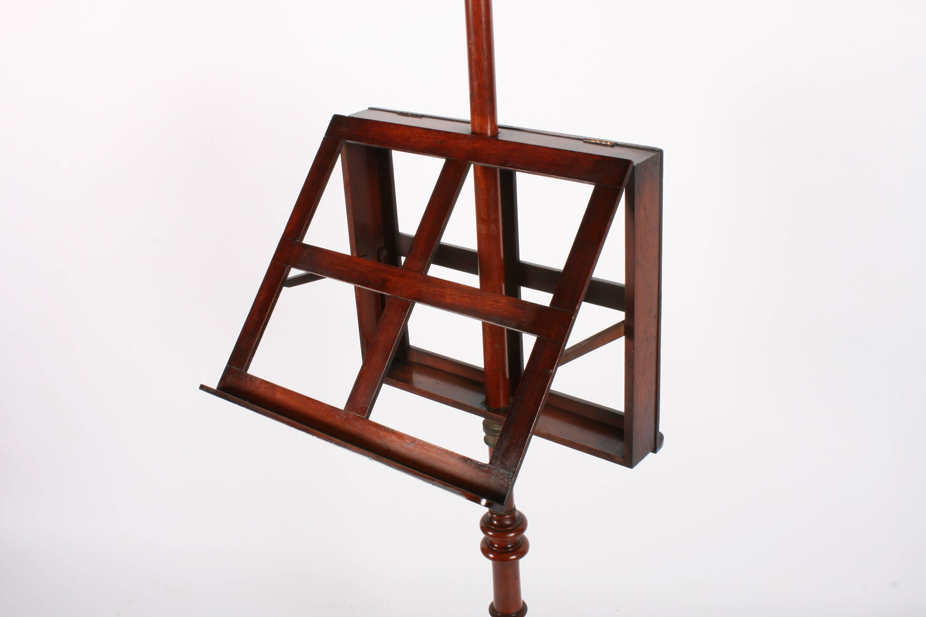 Victorian mahogany duet music stand, circa 1870. With urn shaped top on a large column, there is an adjustable frame with brass collar on mahogany arms. The turned column continues down to a large central block before leading on to cabriole legs on