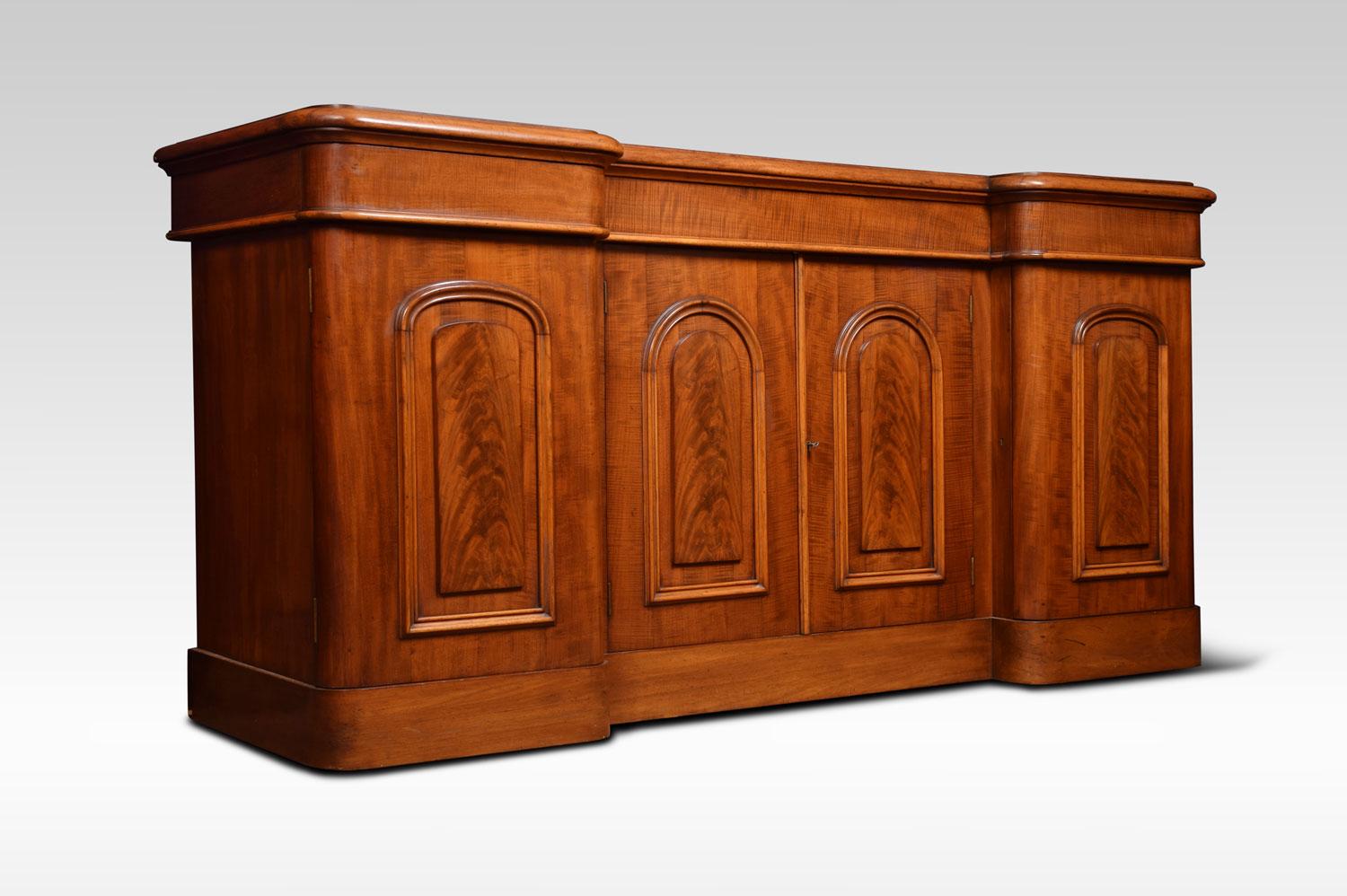 Victorian sideboard, having figured mahogany moulded top above thee ash lined drawers. Above a pair of recessed, arched and panelled figured mahogany cupboard doors. Enclosing a shelf, flanked by further arched and panelled cabinet doors enclosing