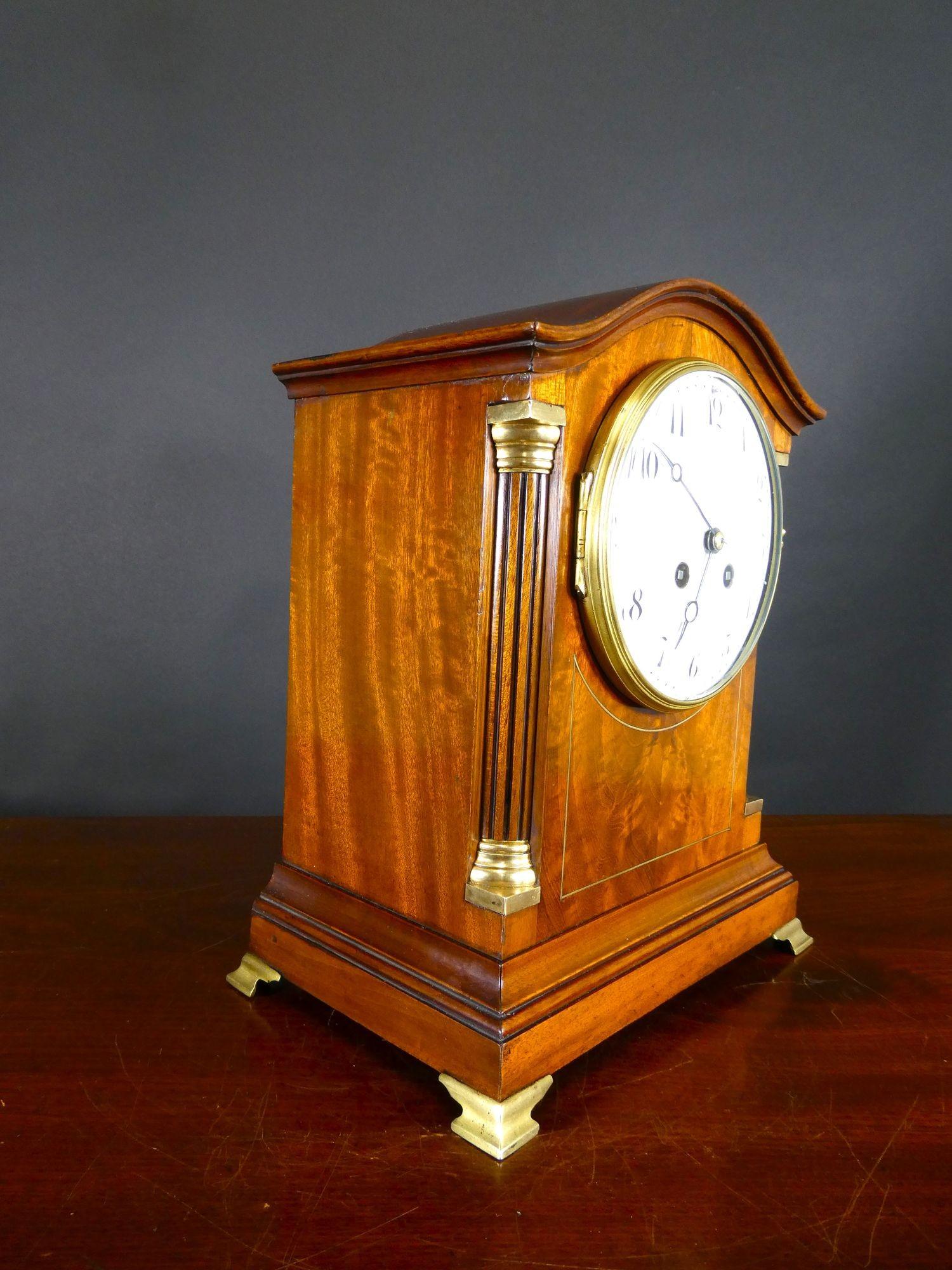 Victorian Mahogany French Mantel Clock

Victorian mantel clock housed in a flame mahogany case with serpentine shaped top, reeded pillars with brass capitals and brass line inlay decoration to the front. Moulded stepped plinth resting on four brass