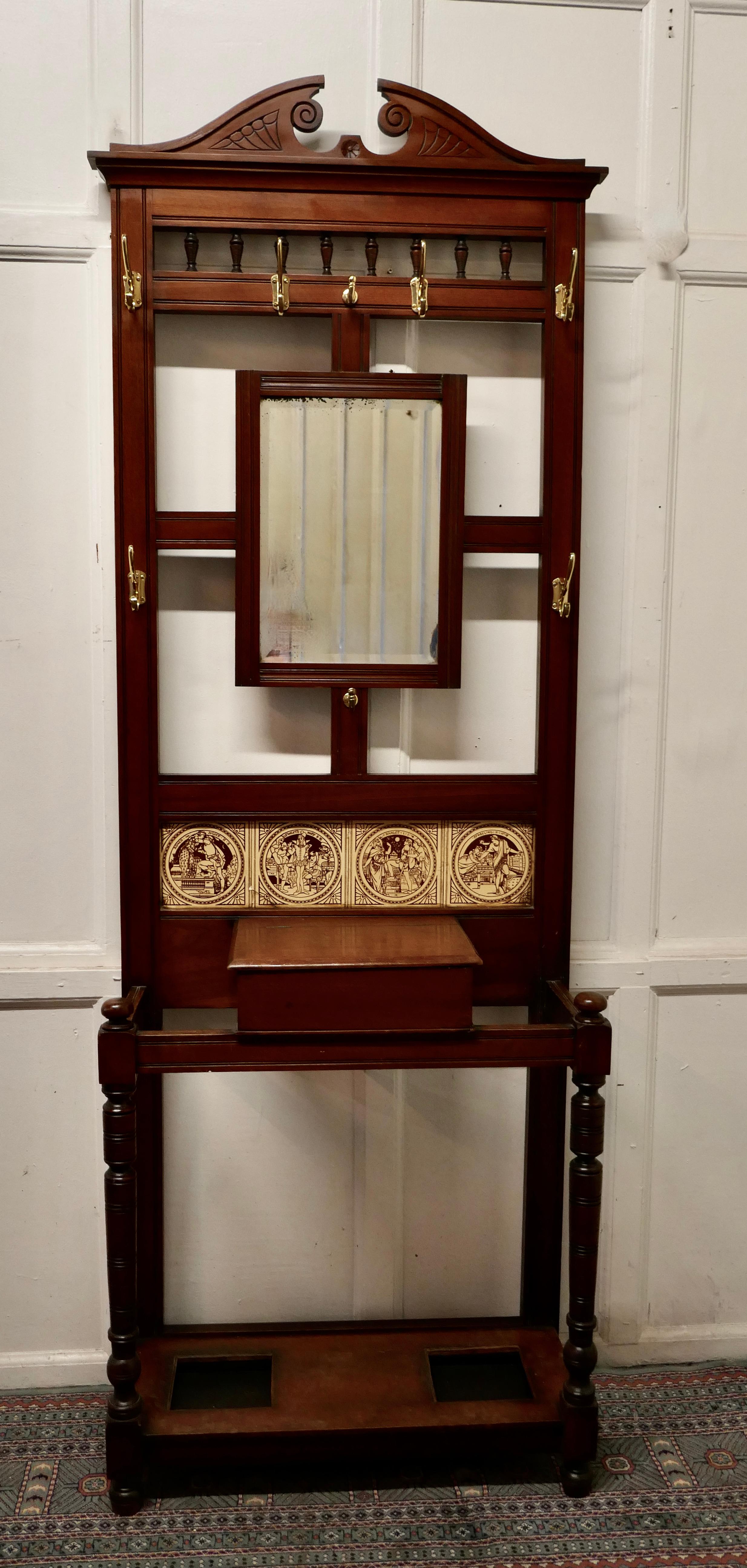 Victorian Mahogany hall stand 

This is a handsome piece, the stand has a central mirror, brass coat/hat hooks and central closing glove box 

The upper section has 4 attractive Victorian Tiles, on the theme of different Shakespeare Plays all