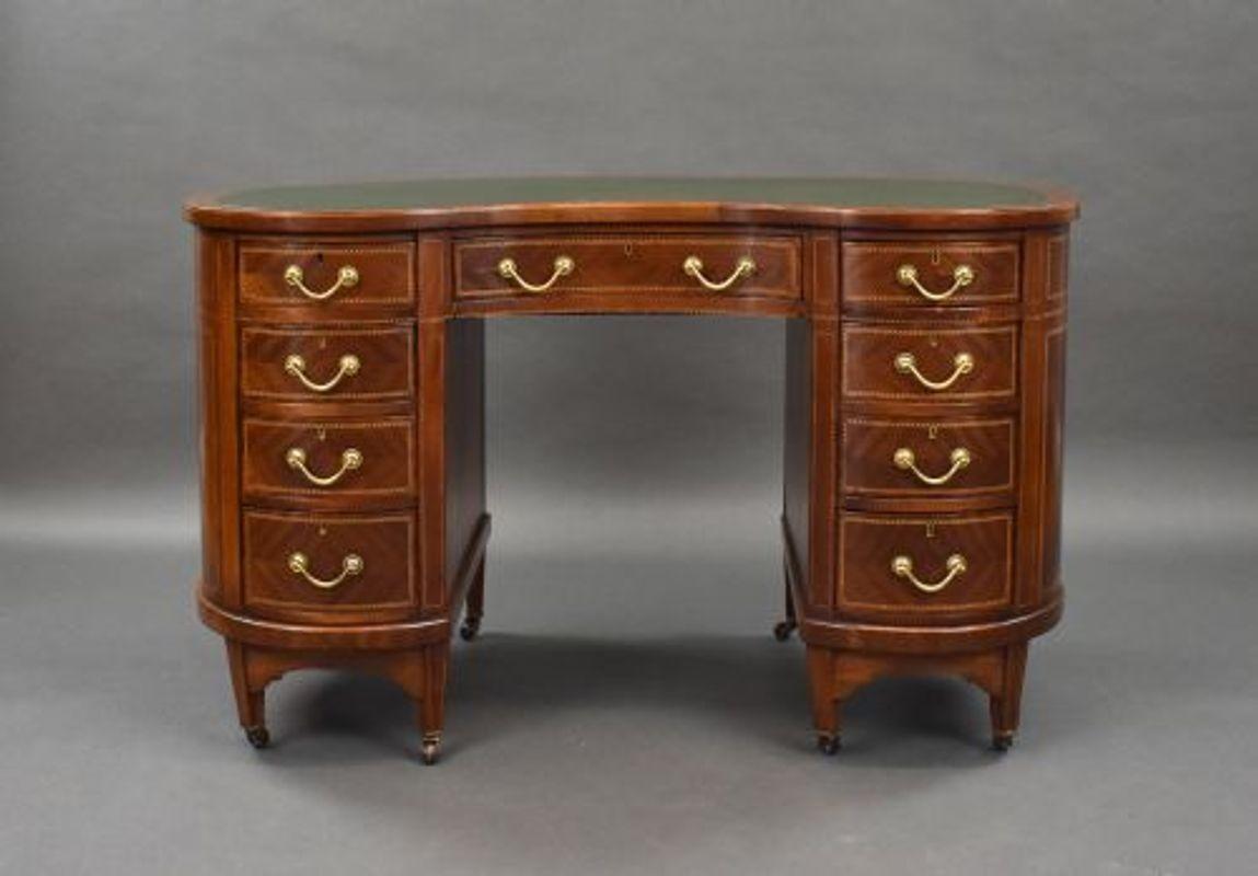 For sale is a good quality mahogany and chequer banded kidney shaped desk by Wolfe & Hollander, having an inset green writing surface above three inlaid drawers with original brass handles. Below this the desk has a further three graduated drawers