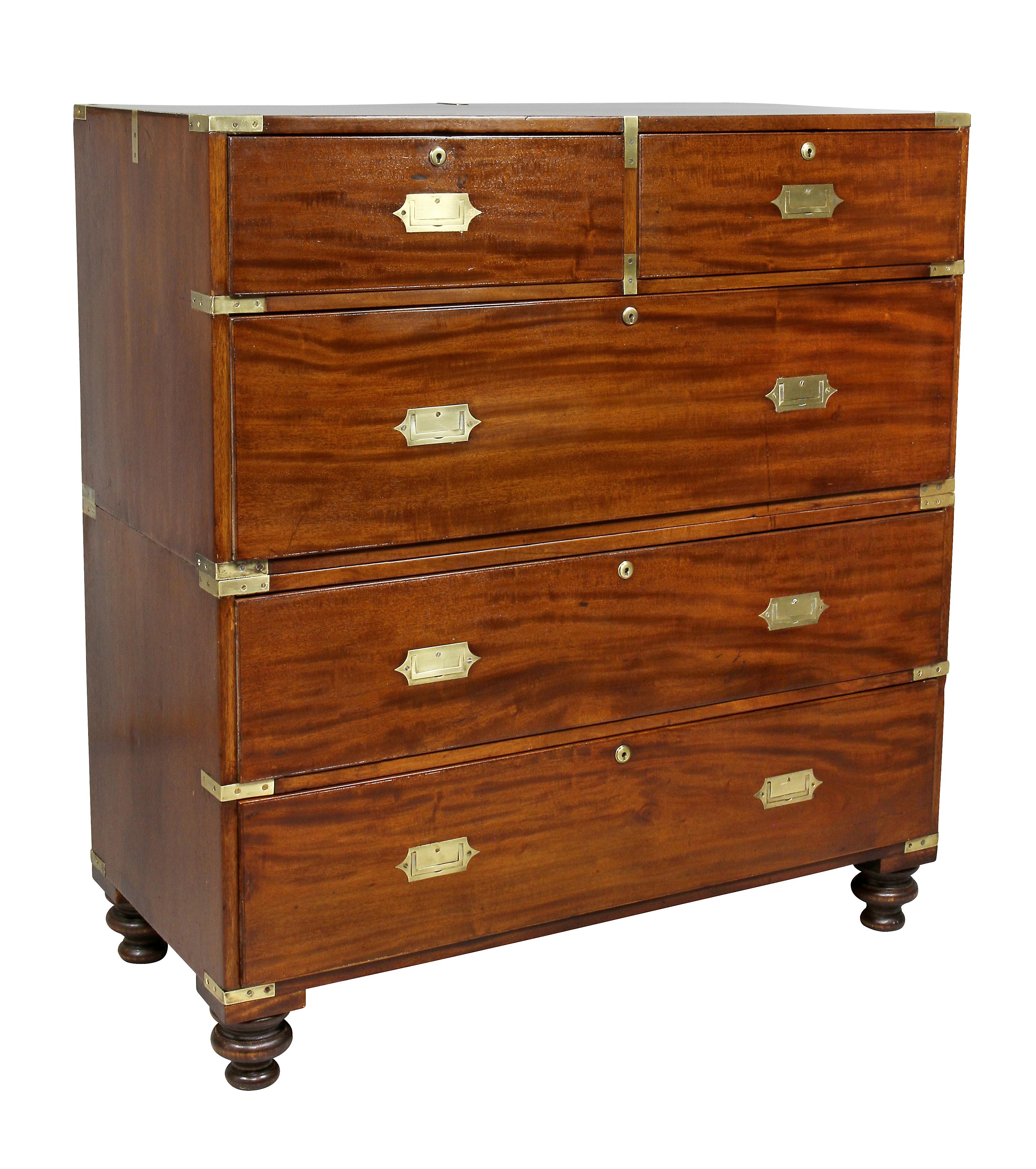 In two sections with rectangular top over two short drawers and three long drawers, toupie feet.