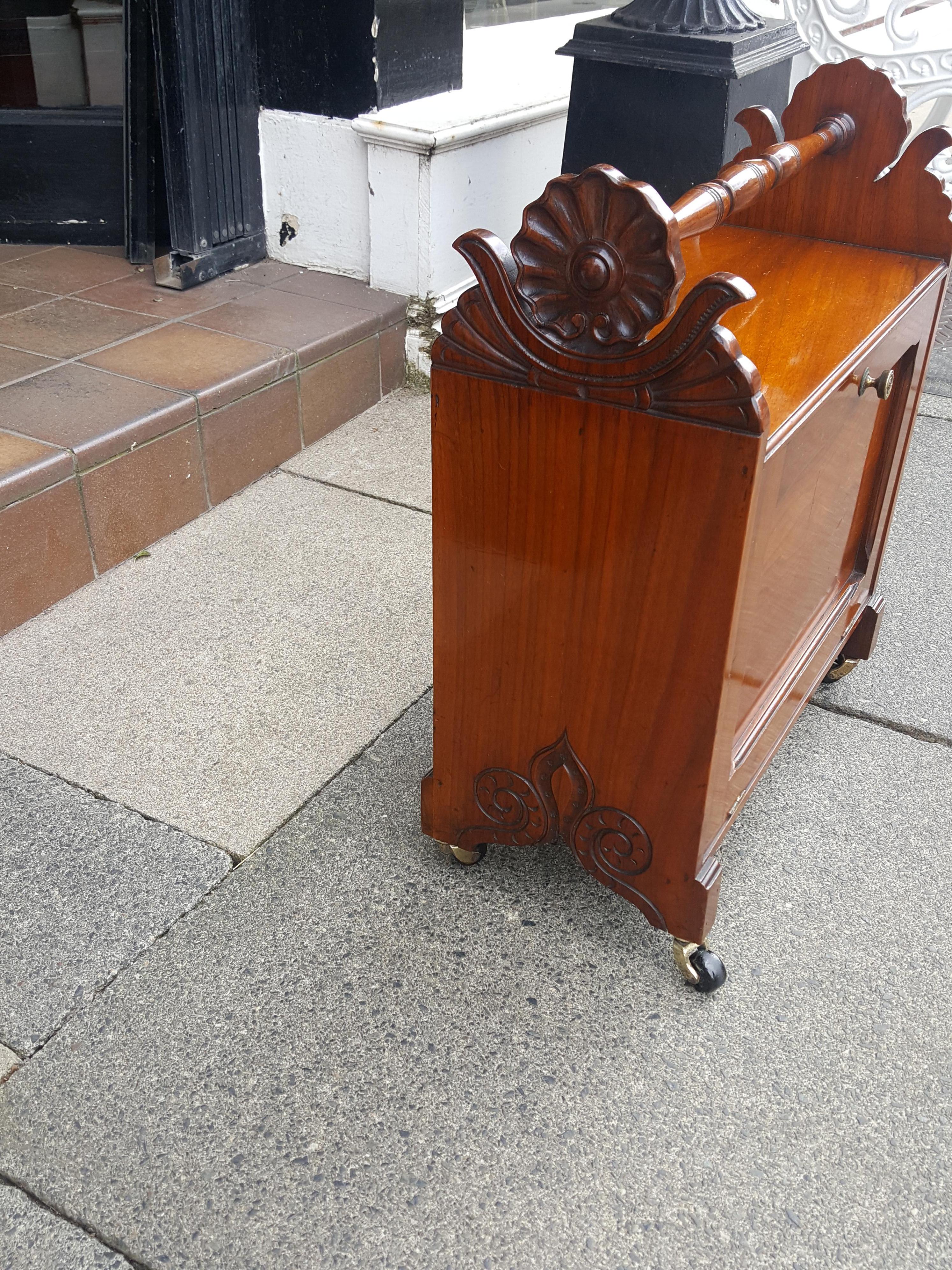 Victorian mahogany enclosed patent Canterbury, M Robinson's improved music cabinet, turned handle, shaped end supports carved with shells and fleur-de-lys, ceramic castors. Measures: 18