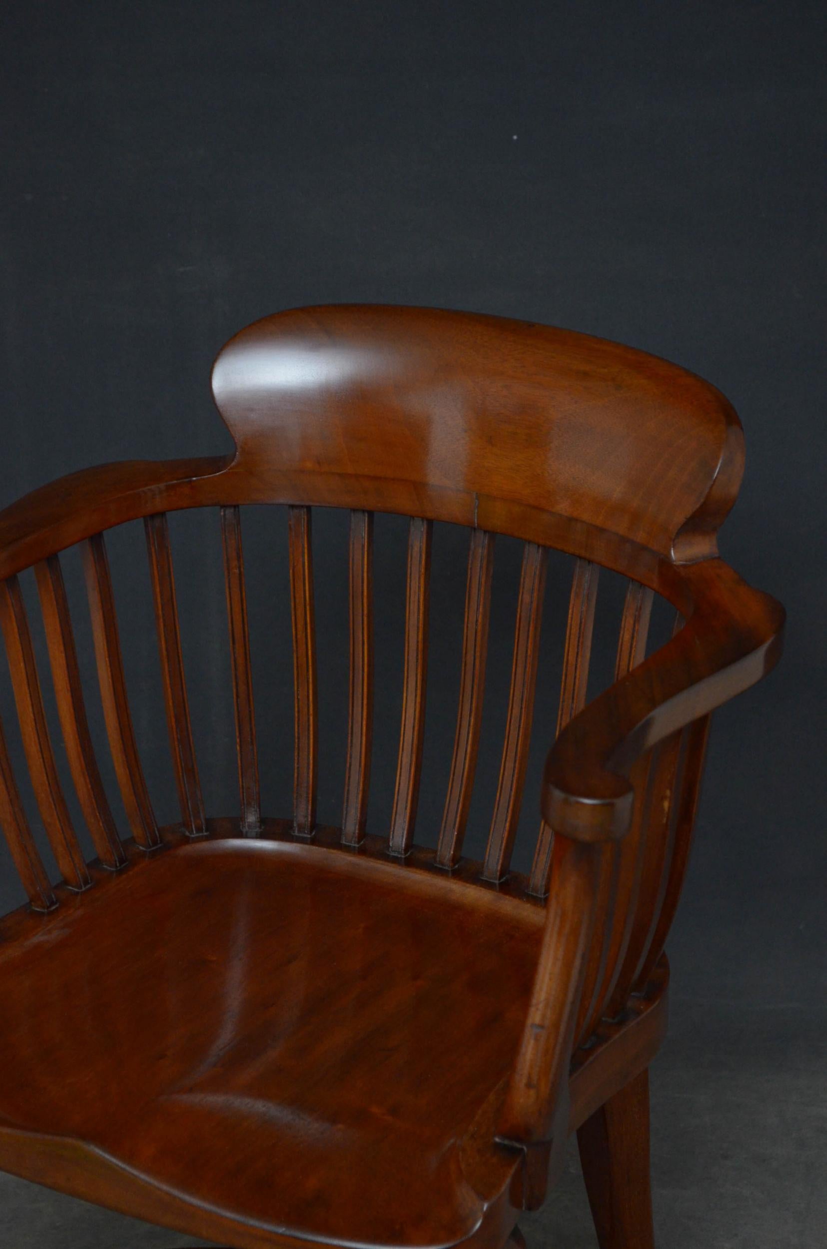 Sn4884 late Victorian desk chair in mahogany, having shaped top rail above reeded slats, outswept arms and generous seat, standing on cabriole legs united by crinoline stretches. This antique chair retains its original finish and patina, all in home