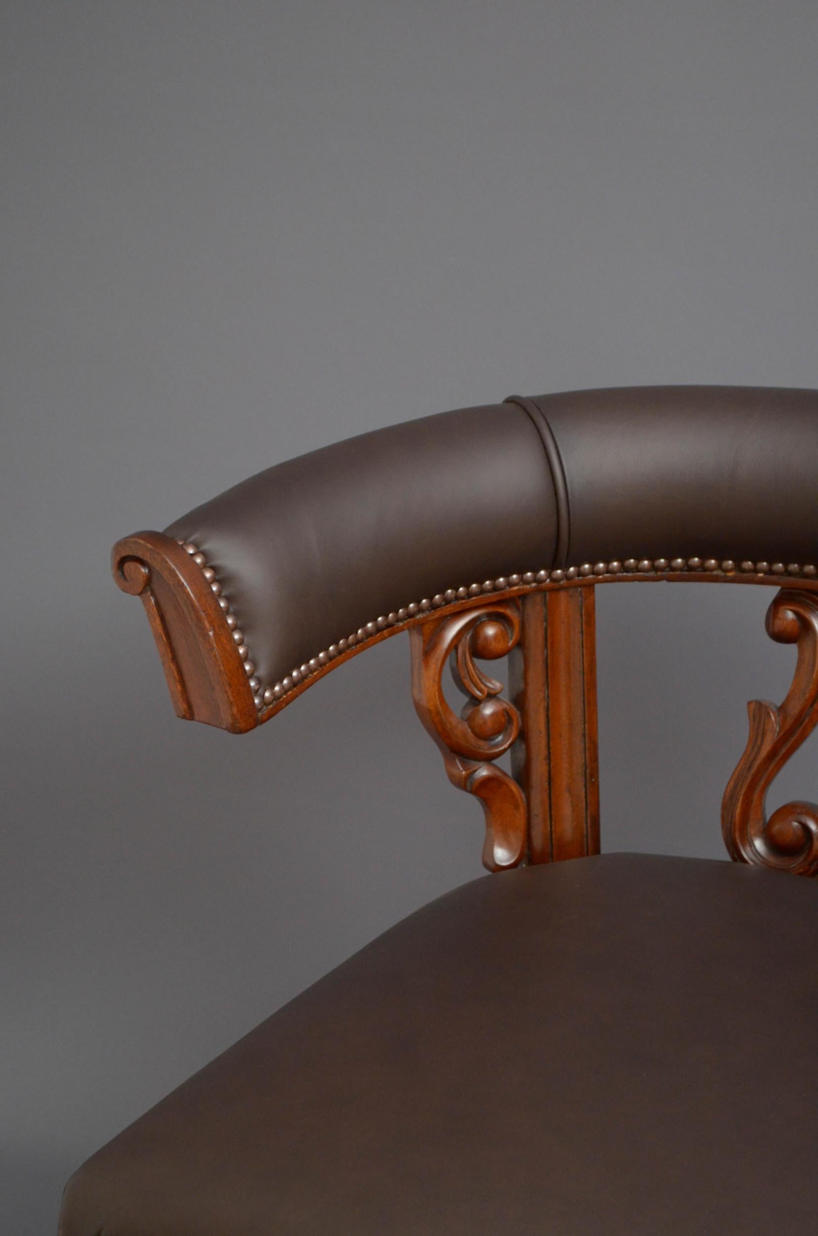 Sn4915, substantial Victorian desk chair or club chair, having brown leather, closely studded top rail supported on finely carved uprights above generous leather seat with closely studded edge, standing on turned, fluted legs terminating in original