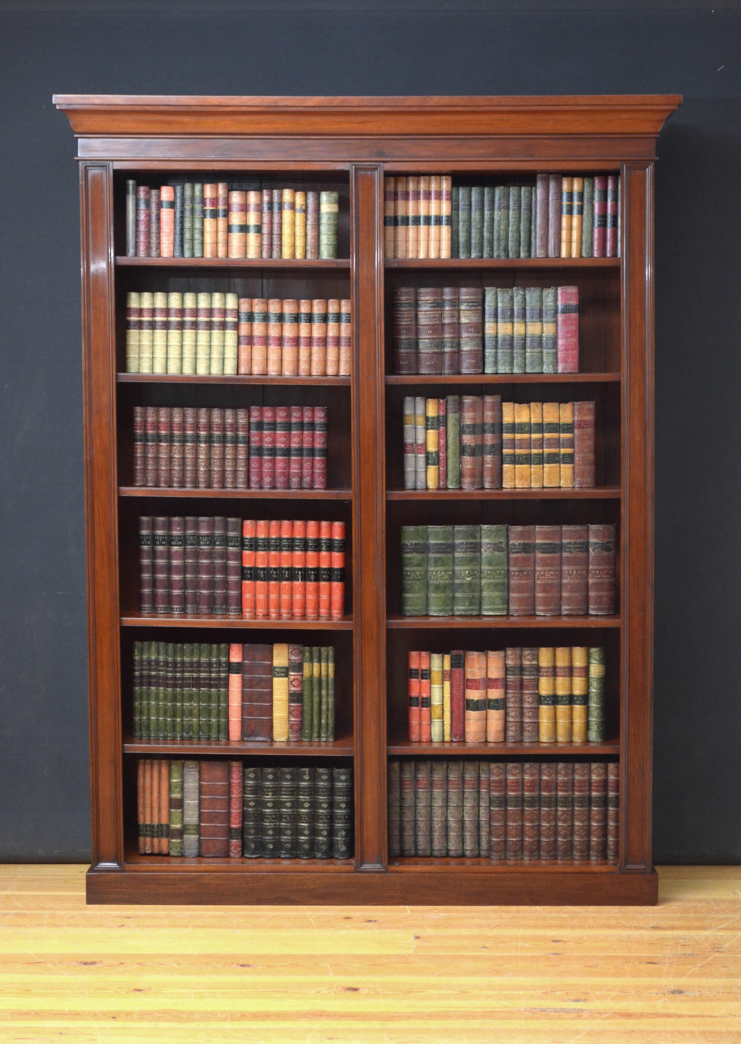 J00 Capacious Victorian open bookcase in mahogany, having cavetto cornice above 2 open sections each with 5 height adjustable shelves, all flanked by moulded pilaster, all standing on plinth base. This antique bookcase retains its original finish,