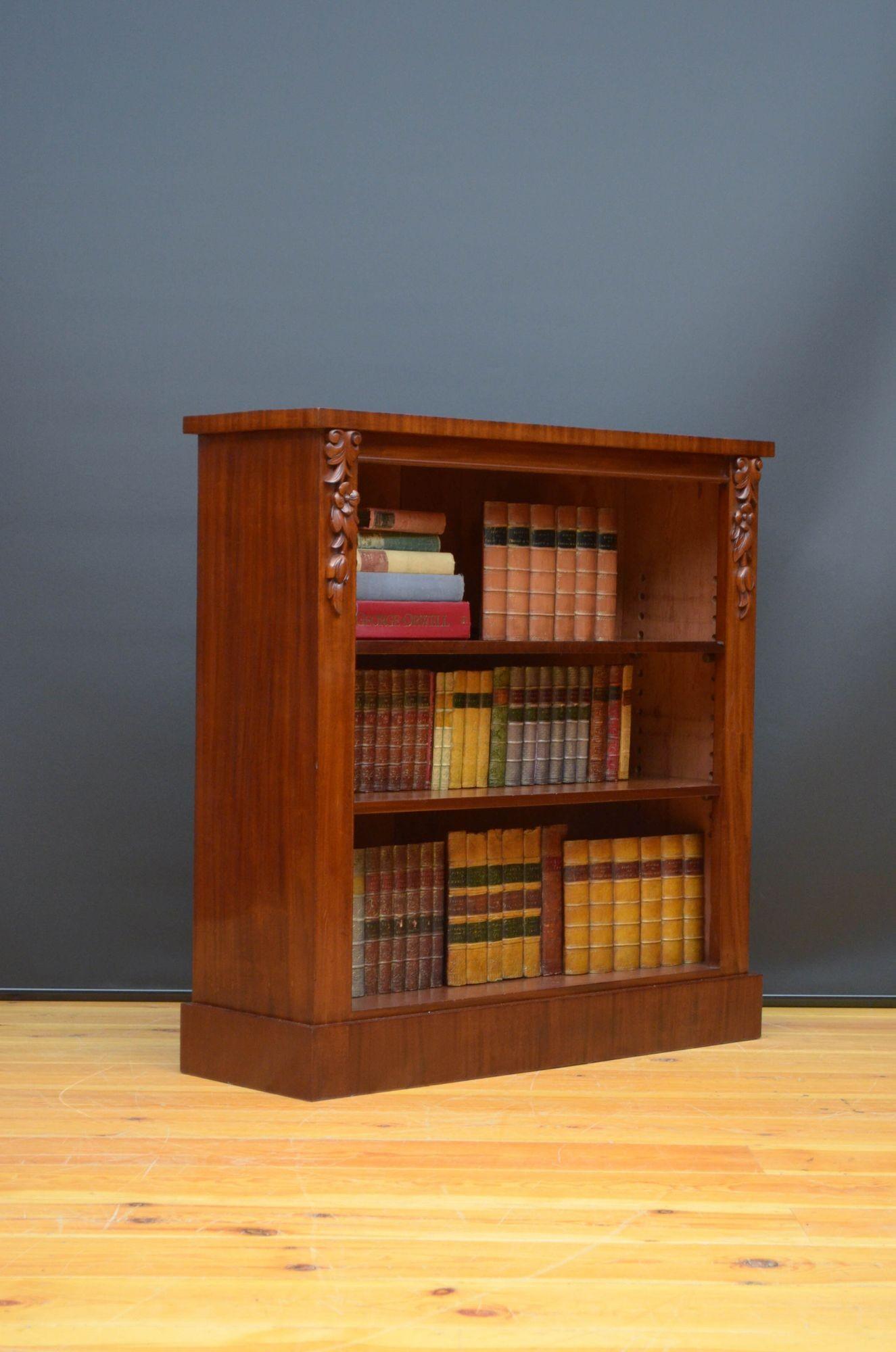 Sn5402 Victorian mahogany open bookcase of narrow proportions with figured mahogany top and two height adjustable shelves, all flanked by floral drop carvings, standing on plinth base. This antique bookcase has bee sympathetically restored and is