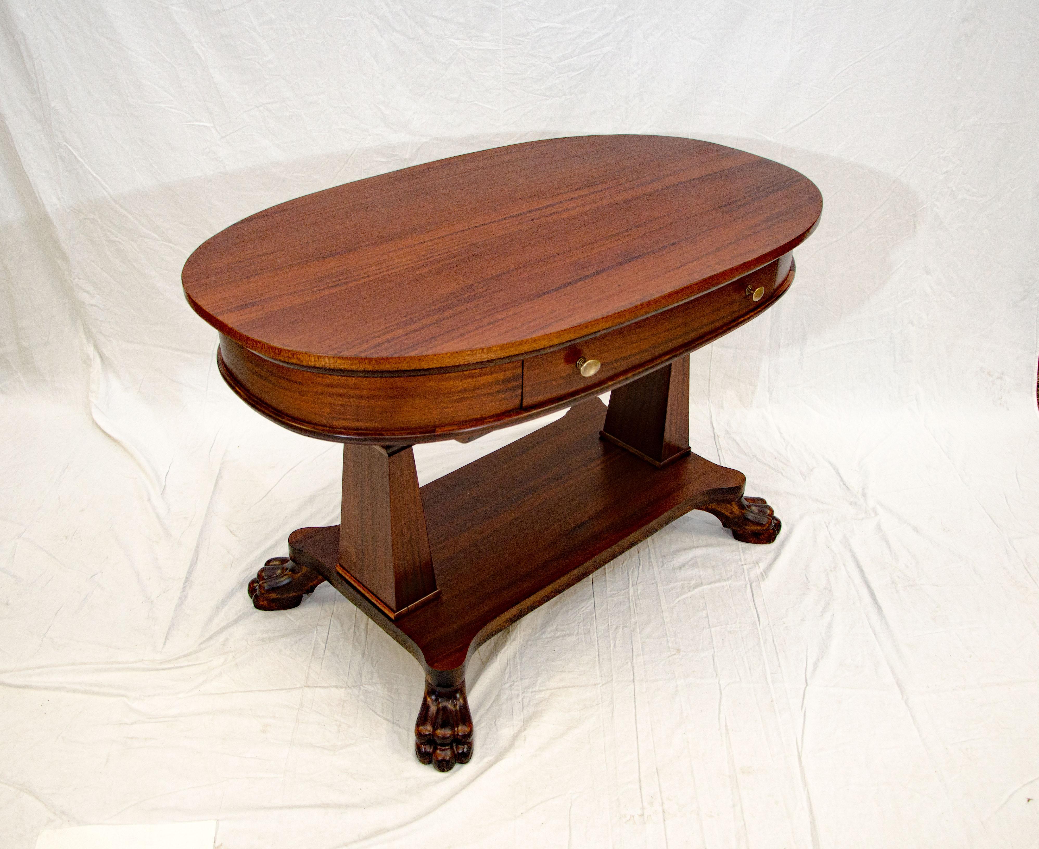 Well designed Victorian mahogany oval library table with brass knobs on the drawer and nicely carved claw feet. A great entryway or occasional table. There is an 18 1/2