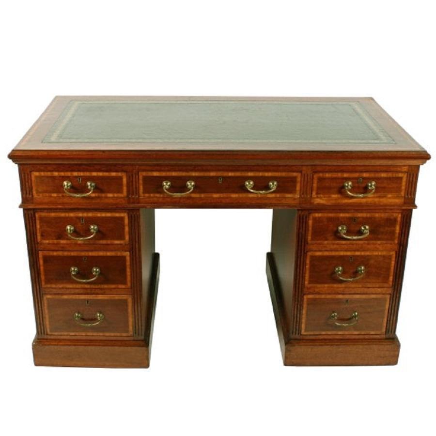 A Victorian mahogany pedestal desk with satinwood inlays and a green leather writing surface.

The desk has nine mahogany lined drawers with satinwood inlaid fronts and brass handles.

The pedestals have satinwood inlays to the outside facing