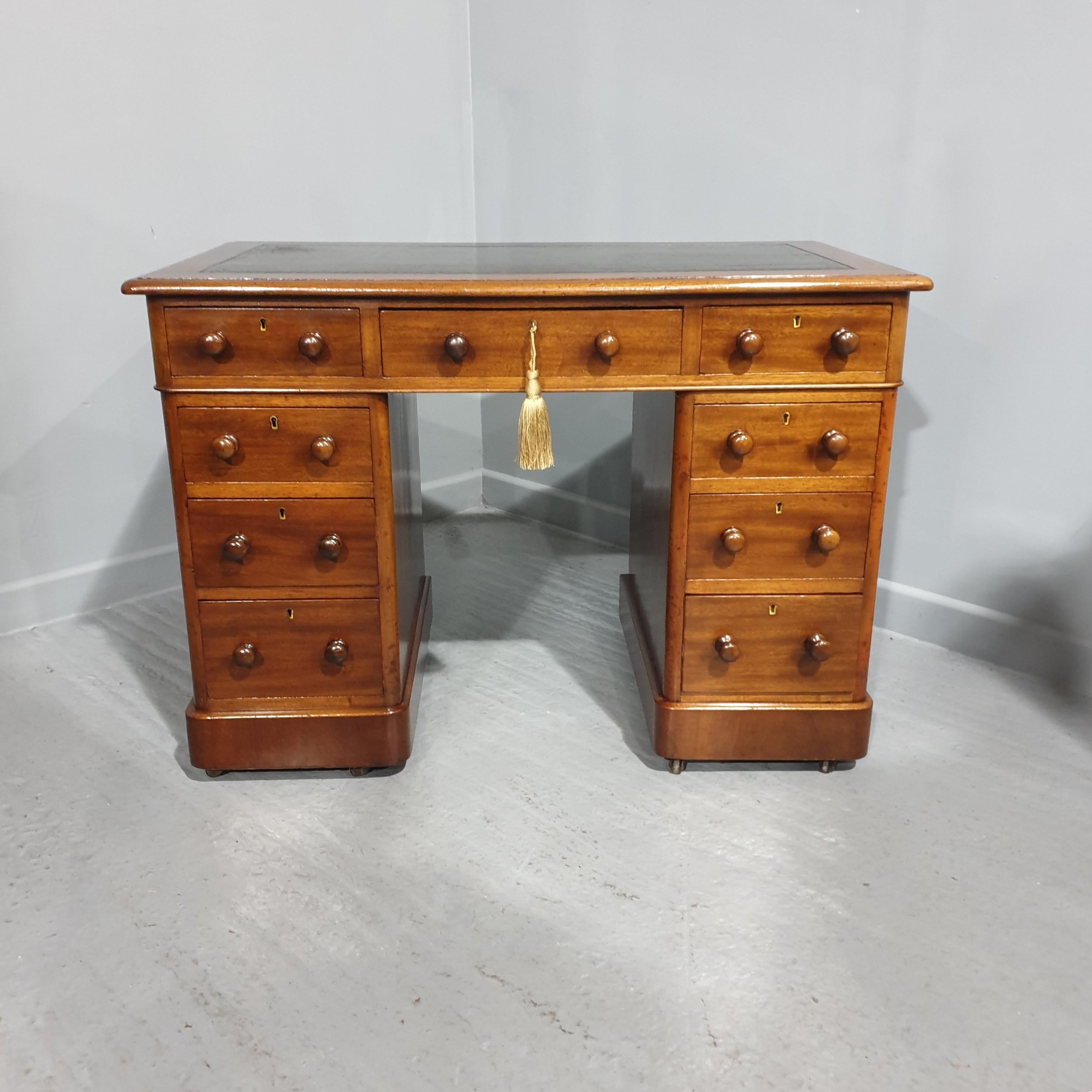 A super small Victorian mahogany three piece pedestal desk, with nine drawers, original condition with green leather top, curved edges with turned mahogany knobs, in excellent condition.