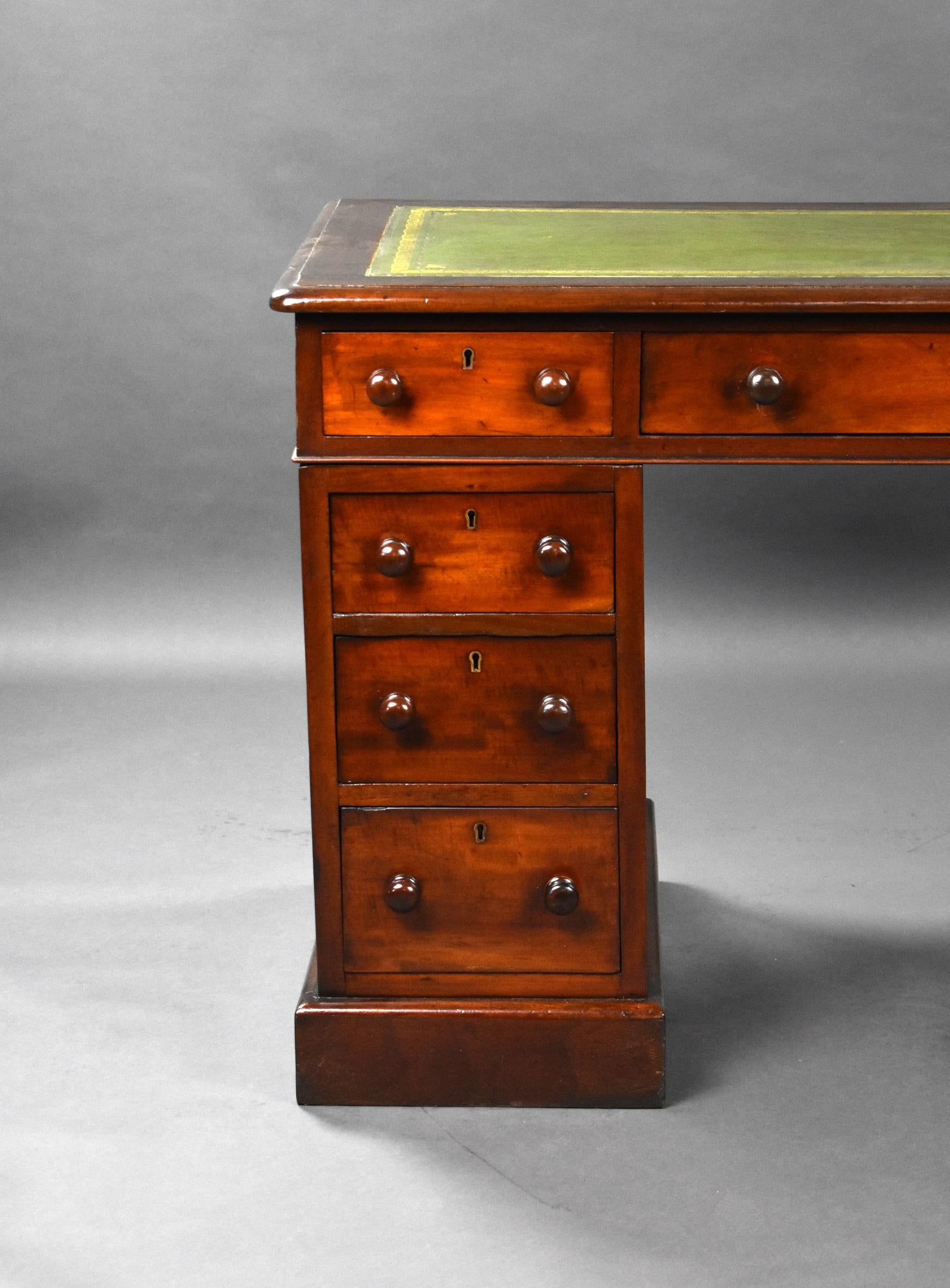 Victorian mahogany pedestal desk in good condition. The top inset with a green leather with gold tooling to the edge with corner motifs, below the desk has three drawers and sits on two pedestals with three drawers in each all with wooden knob