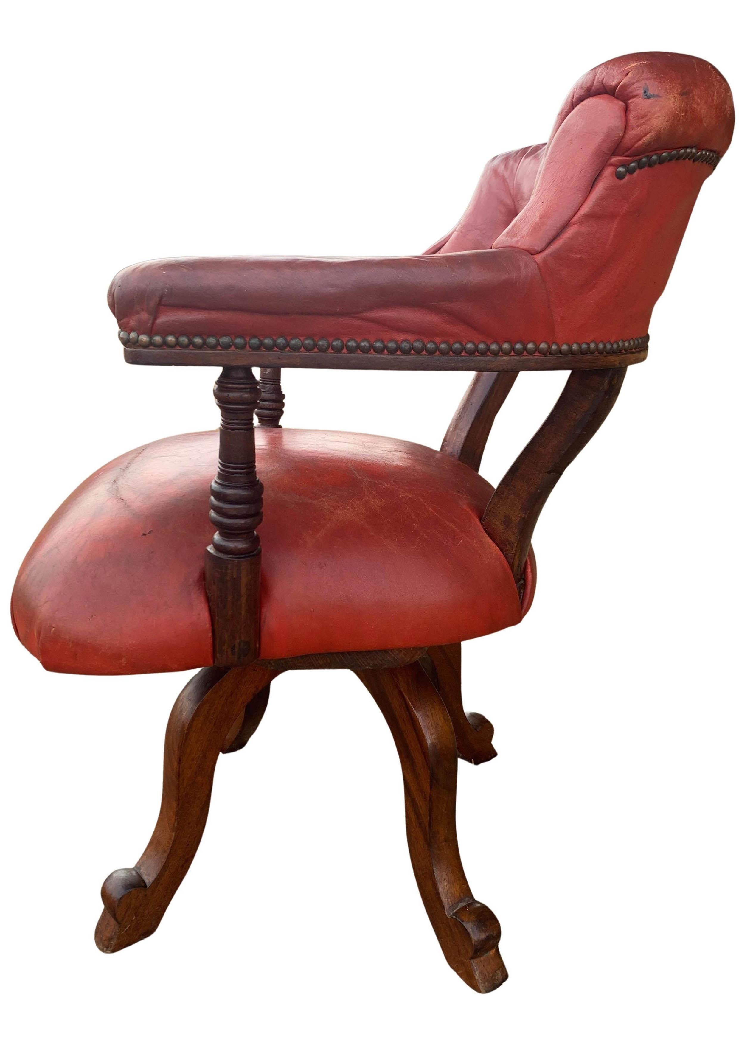 Victorian Mahogany & Red Leather Ecclesiastical Button Back Revolving Desk Chair With Stud Detailing & Iron Swivel Base 

Curved upholstered deep buttoned red leather backrest, with padded wraparound arms on turned supports, with shaped legs.

Circa
