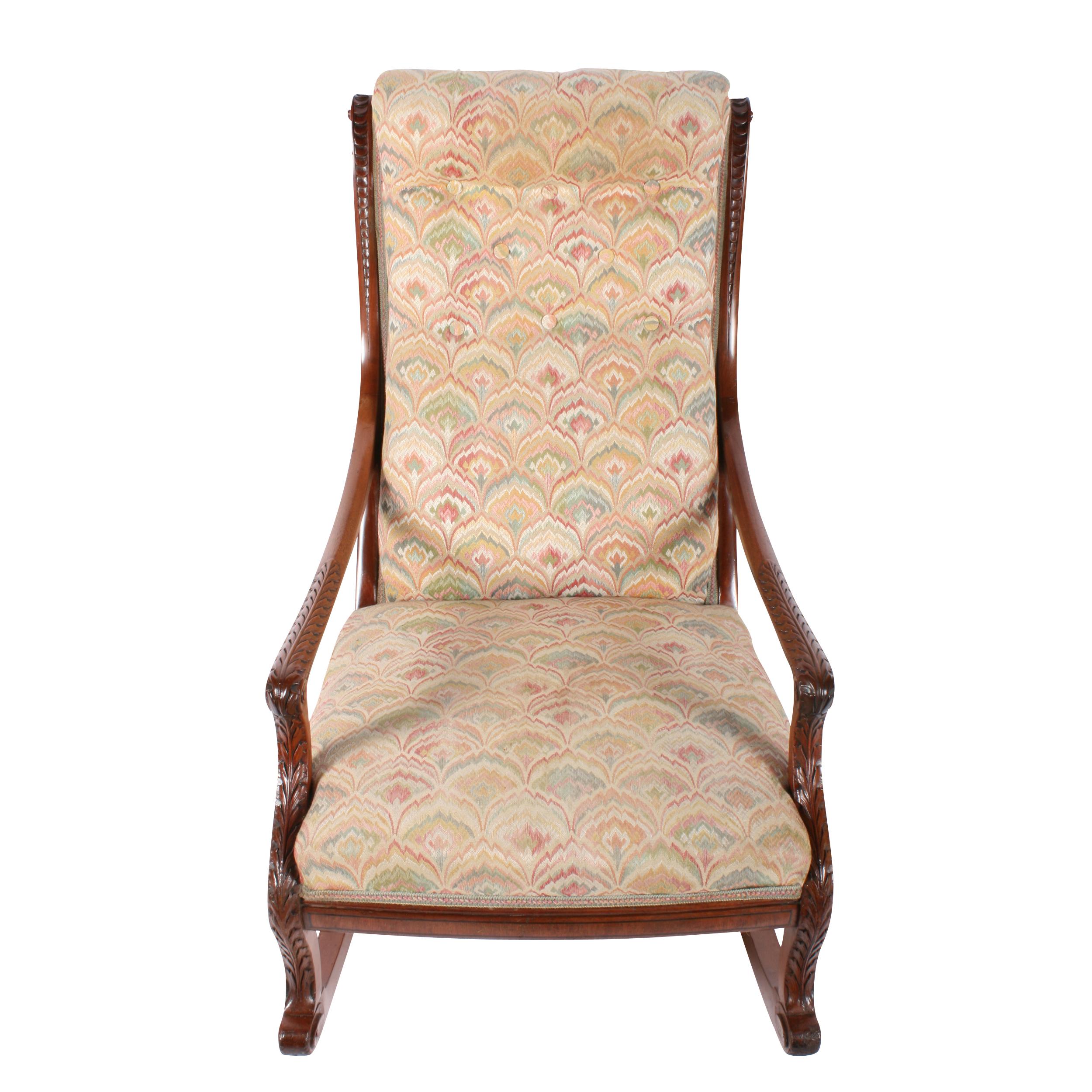 A 19th century Victorian mahogany rocking armchair.

The chair has long acanthus carved arms with the carving continuing along the front of the cabriole legs.

The chair has a high back with button back upholstery and the mahogany frame either