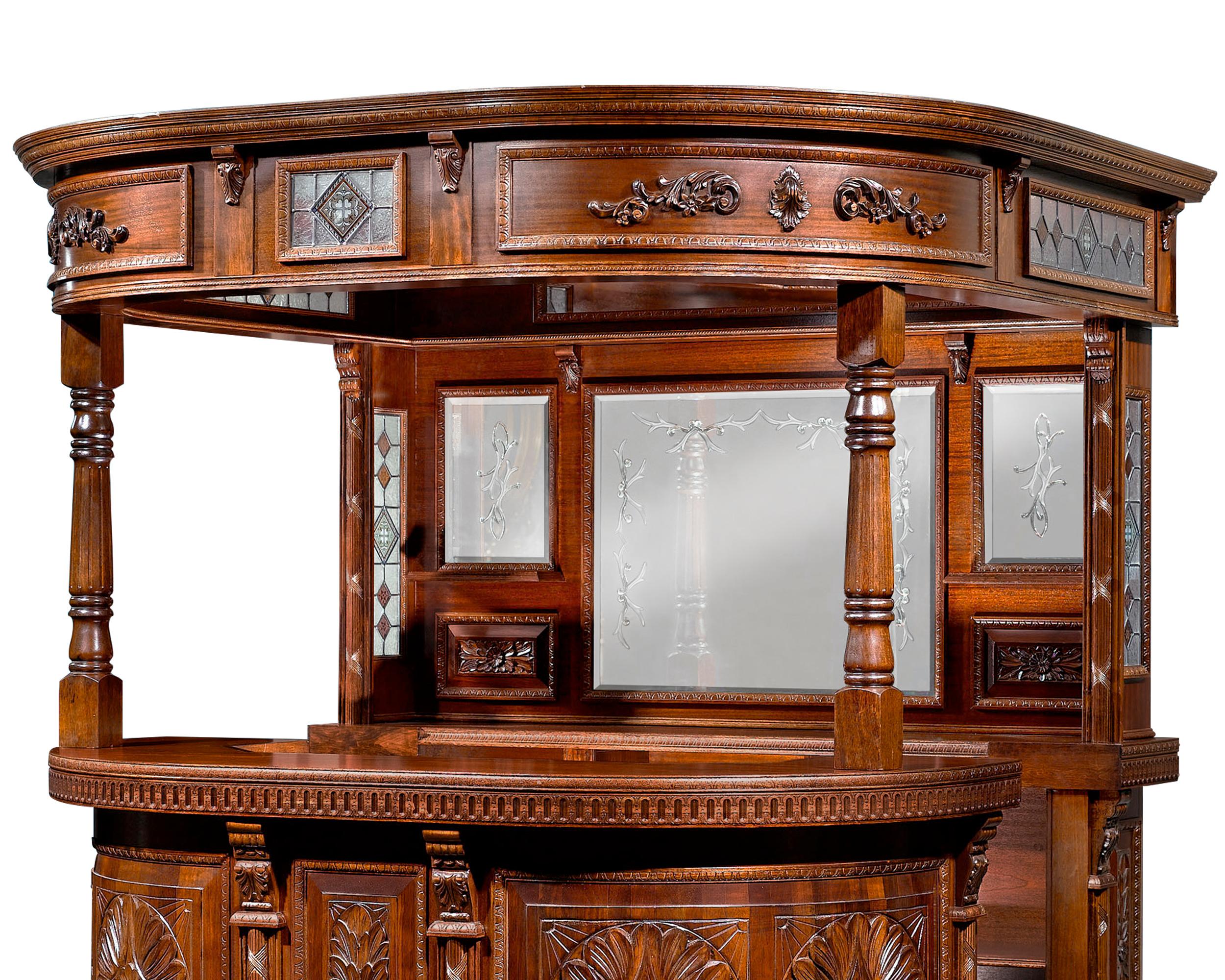 This monumental Victorian mahogany canopied bar possesses an airy spaciousness thanks to stained glass panels of superb quality and craftsmanship. Placed in the canopy and on the sides of bar, the colorful panes beautifully complement the bar's