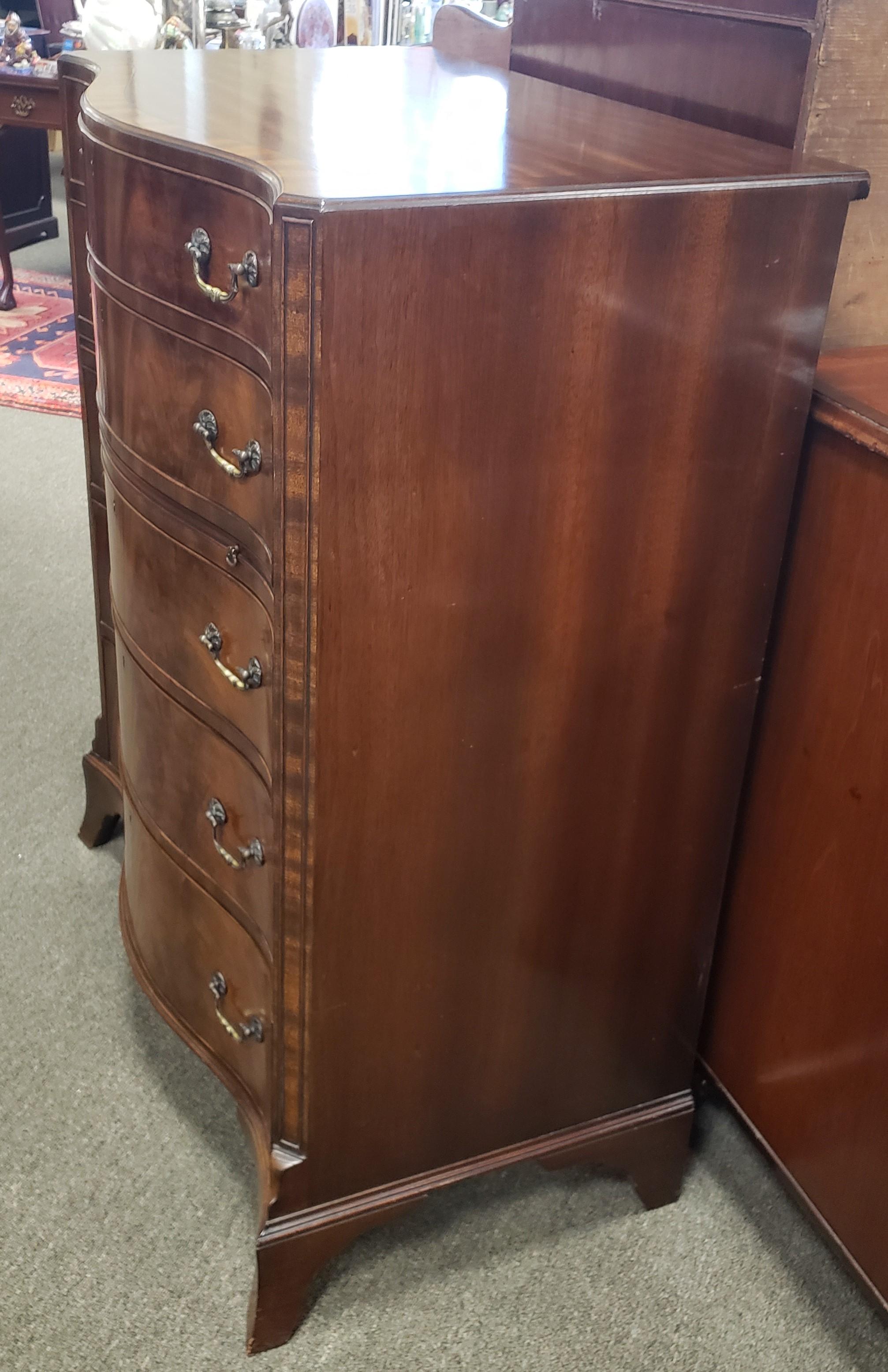 Victorian mahogany serpentine chest of drawers with inlay and crossbanding. The top of the chest is fiddle back mahogany while the front is flame mahogany. This piece also features a pullout / pull-out writing surface.