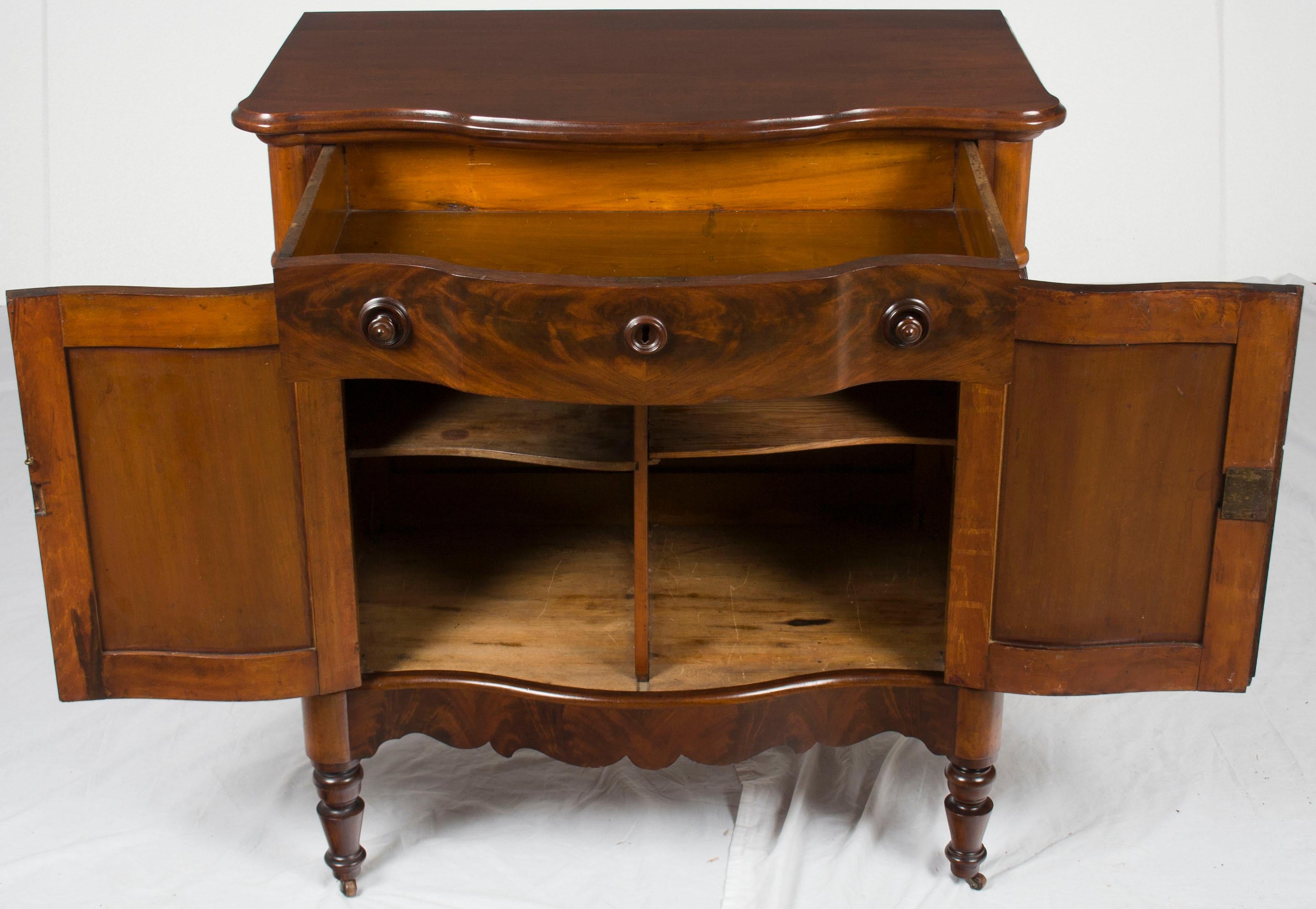 This is a Victorian period mahogany side cabinet from England. Perfect for miscellaneous storage in any room of the house. It would make a particularly small serving buffet in a dining room.

The origin of this cabinet is England and it was made