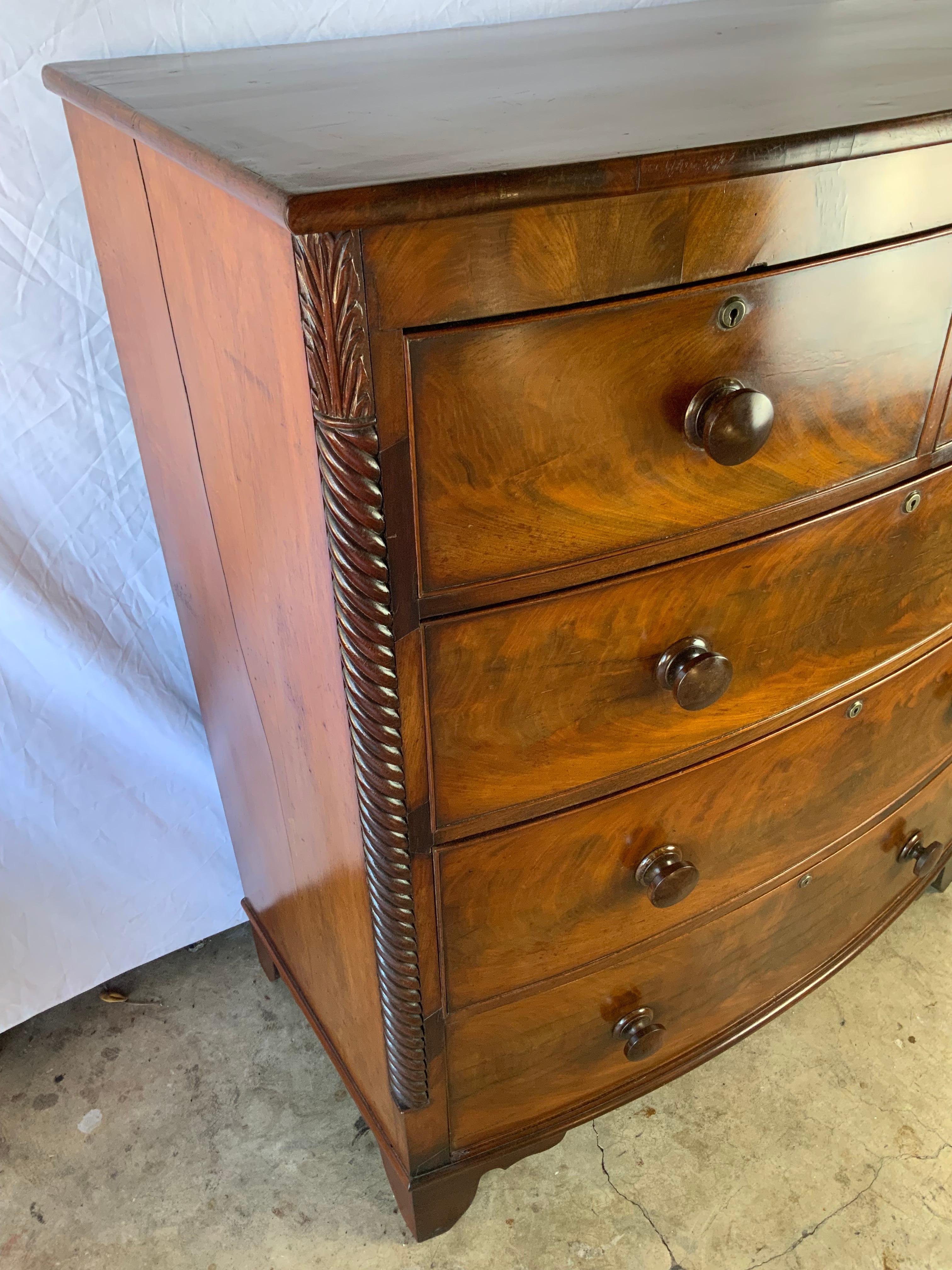 A very attractive two over three English Mahogany chest of drawers with carved rope twist quarter columns ending in tall bracket feet.  Original surface with a great color and patina. Large deep drawers that still have the original paper liners and