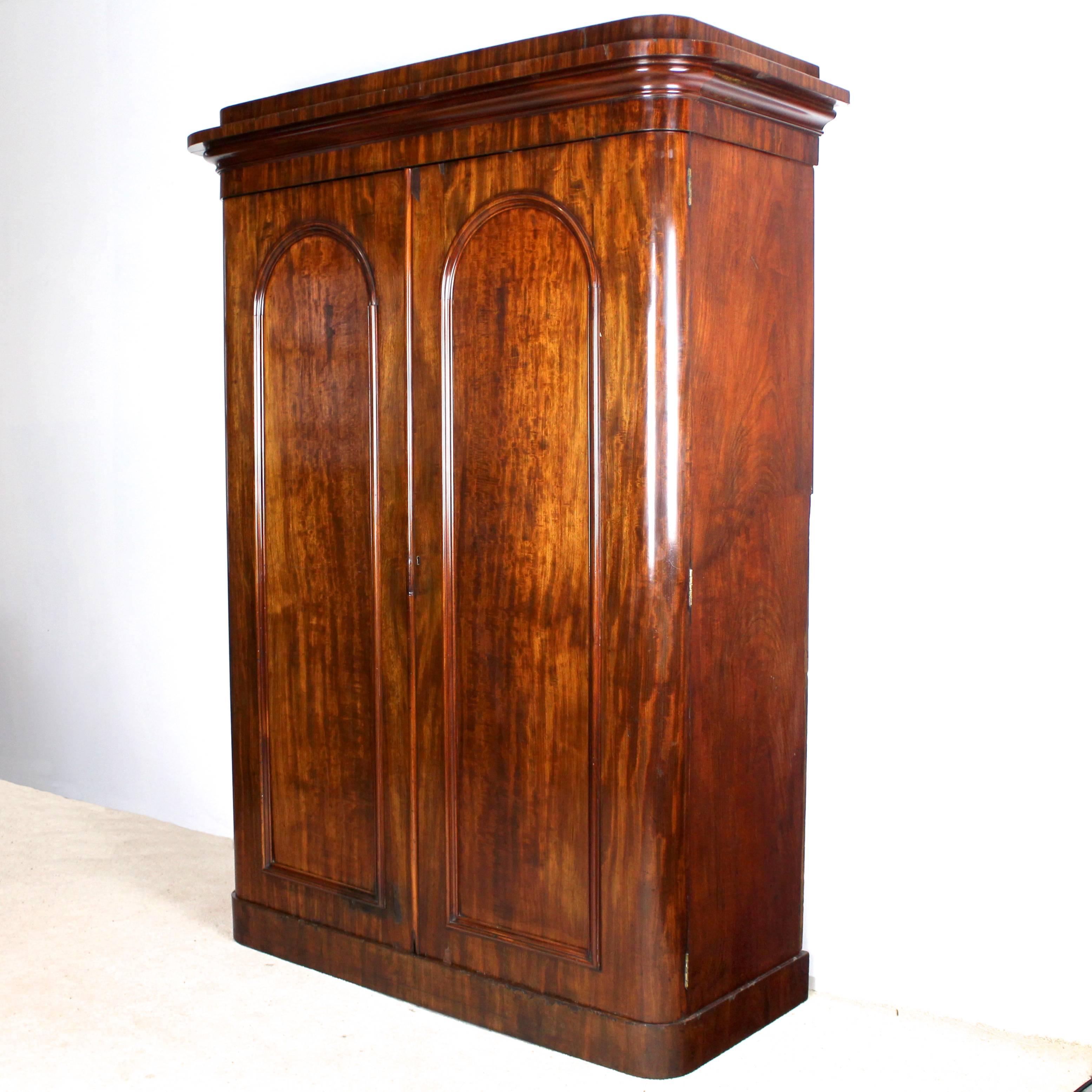 A good quality Scottish mid-Victorian mahogany two-door wardrobe dating to circa 1860-1870 by highly esteemed Glasgow cabinetmakers, Wylie & Lochhead. With a rounded rectangular moulded cornice above two arched panelled doors and standing on a