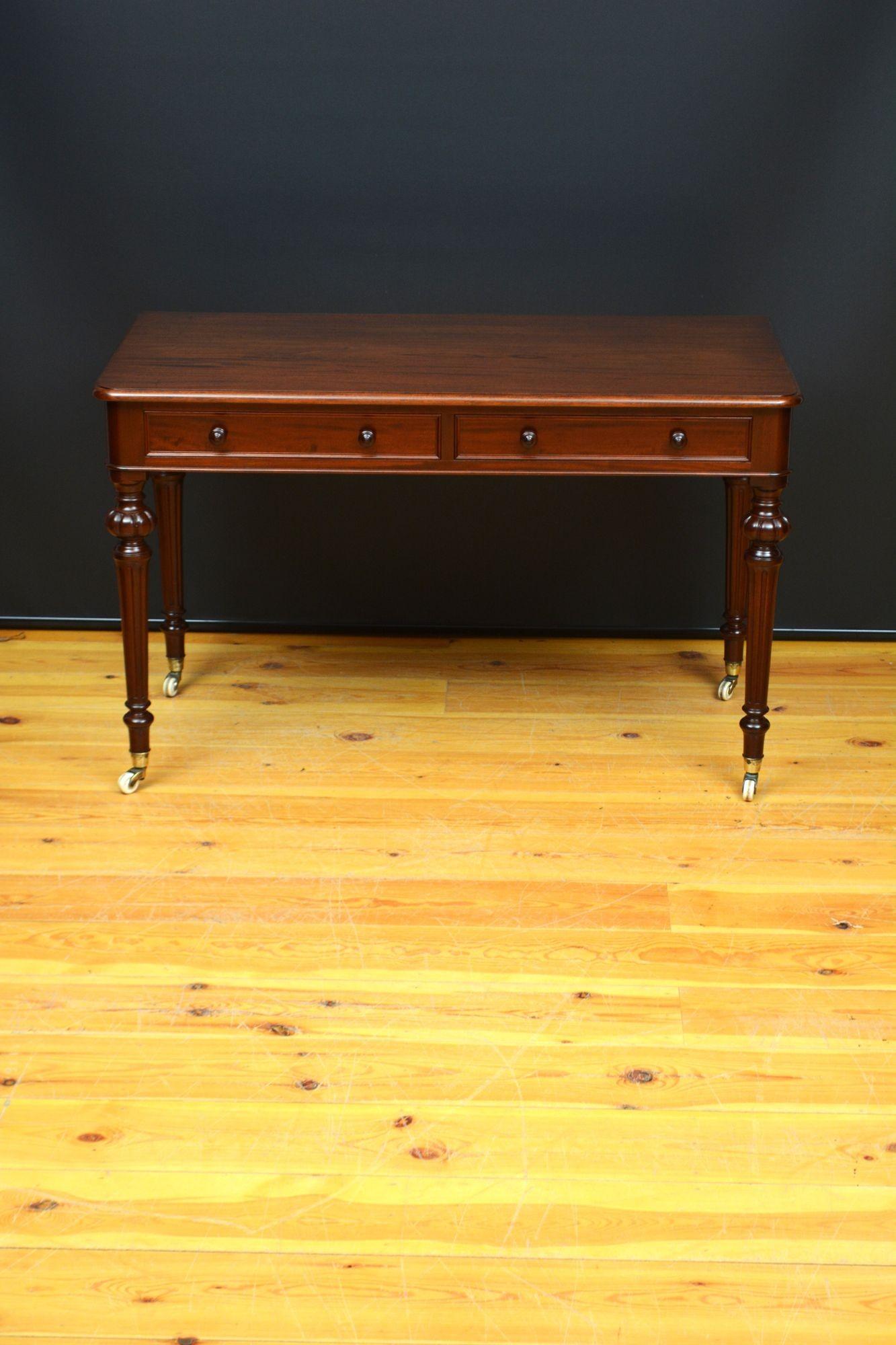 St063 Tavolo da scrittura o da toeletta in mogano massiccio di epoca vittoriana, con piano in mogano figurato con bordo modellato sopra due cassetti a fregio modellato dotati di pomelli a rilievo, il tutto poggiante su quattro gambe intagliate e