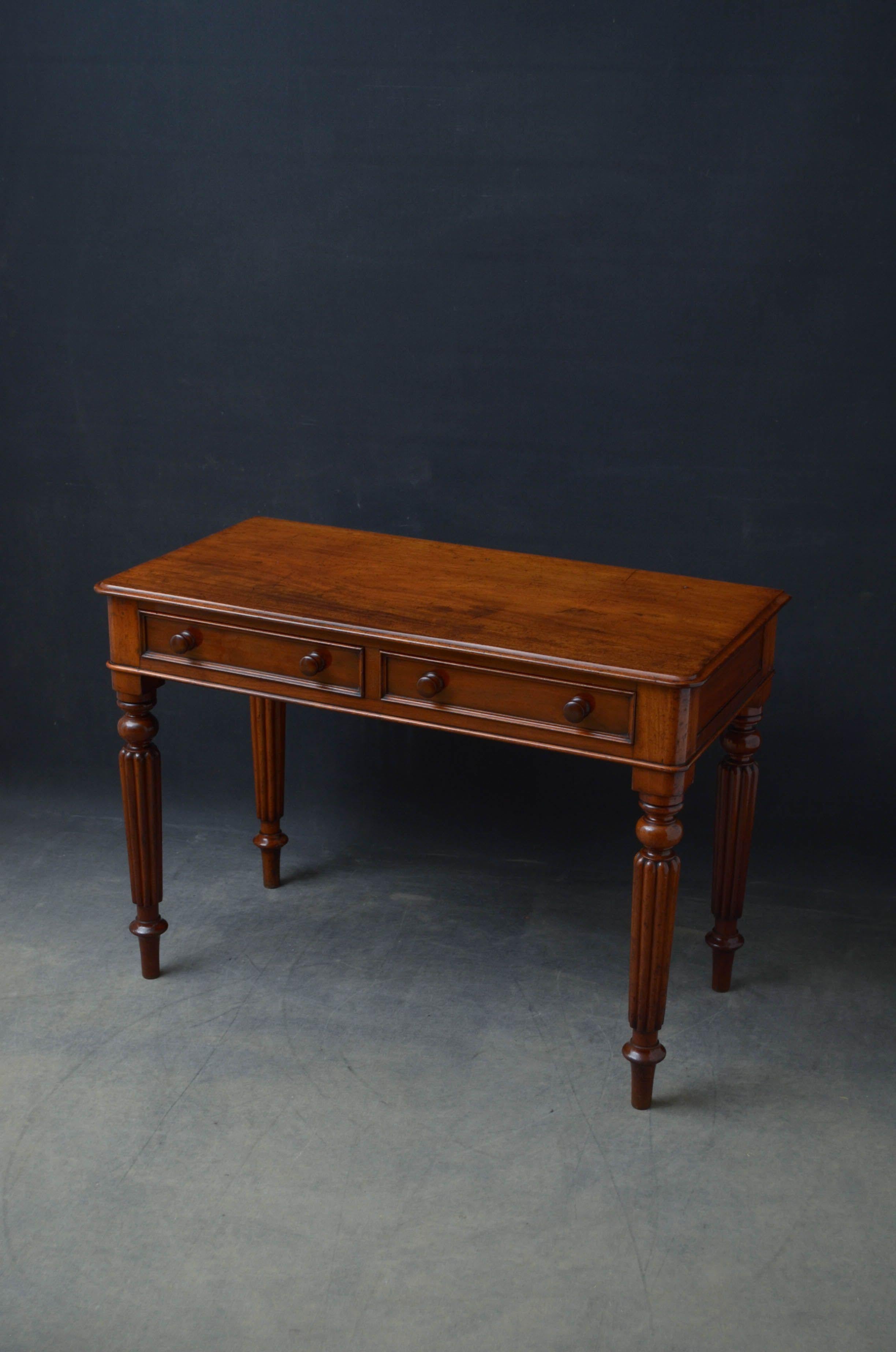 Sn5223 Attractive Victorian writing desk in mahogany, having figured top with moulded edge above two moulded and mahogany lined drawers fitted with turned knobs, flanked by rounded corners, all standing on turned, fluted and tapered legs. This