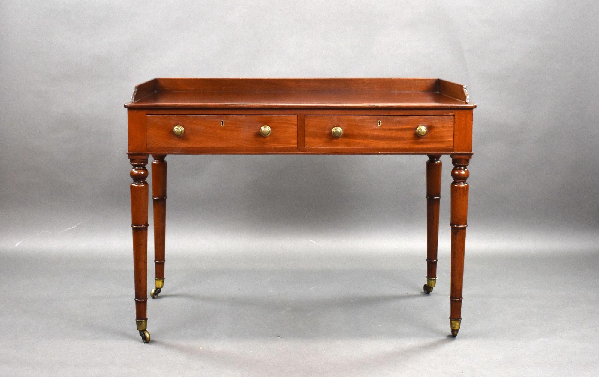 For sale is a good quality Victorian mahogany writing table, having a galleried top, above two oak lined drawers with fine hand cut dovetails and brass handles. Standing on elegant turned legs, terminating on fine brass castors, this table remains