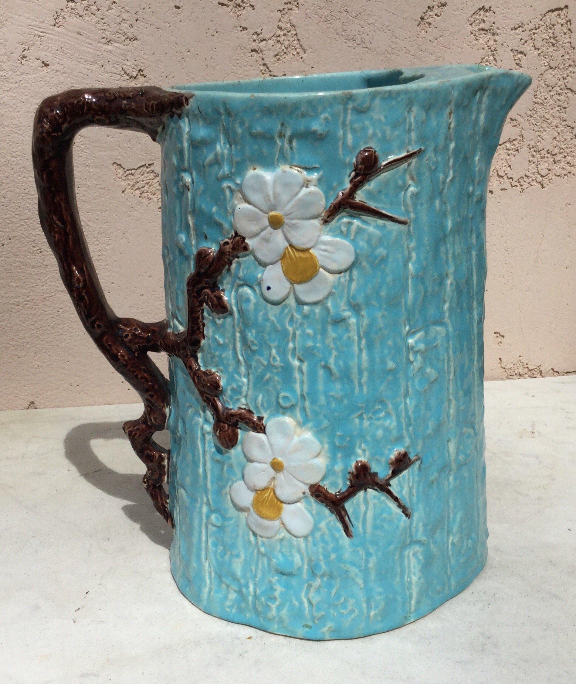 Very large Victorian aqua Majolica Dogwood flowers pitcher signed Joseph Holdcroft, circa 1890.
Rustic style.
Hairlines.