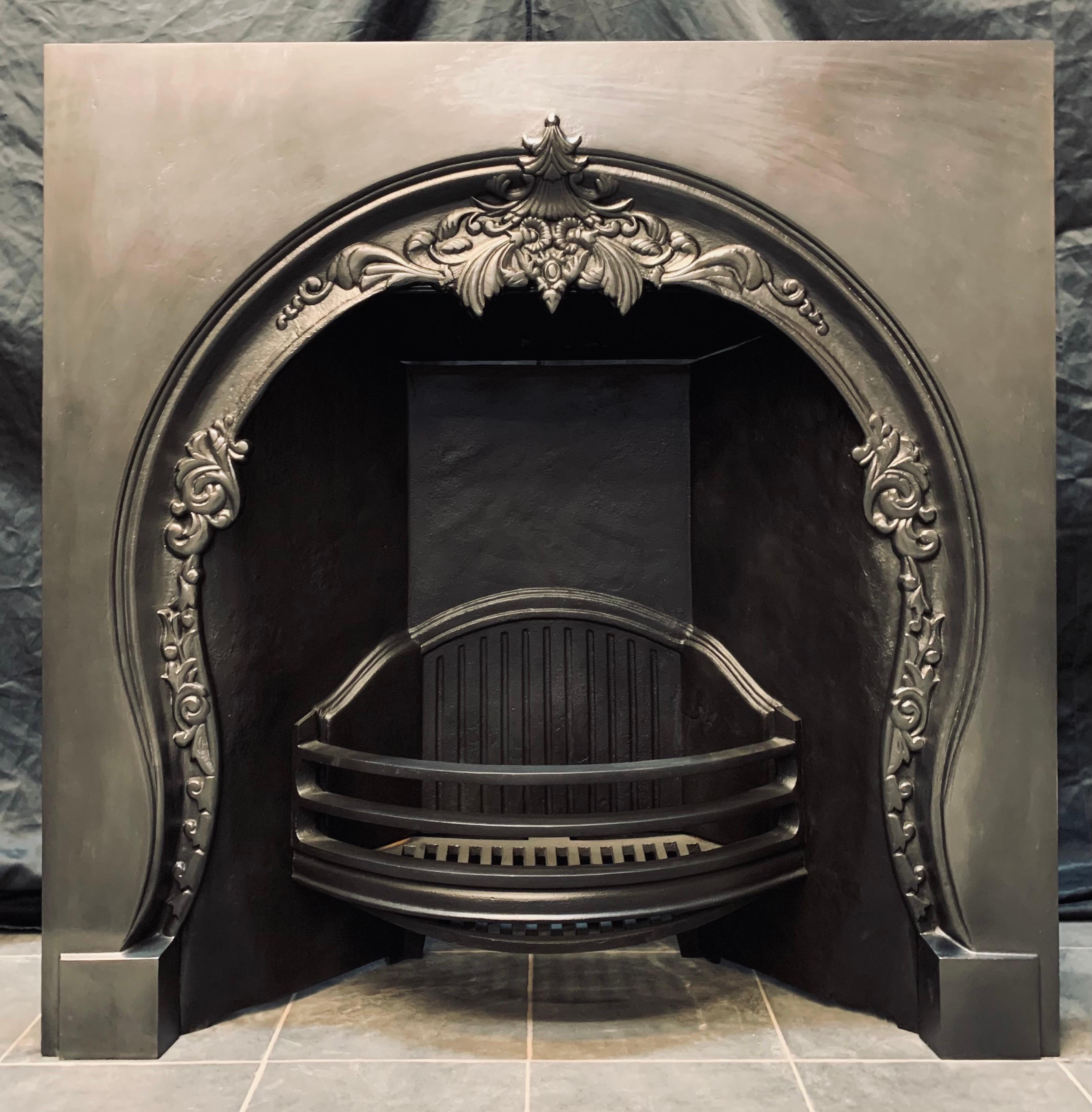 A charming Victorian style horse shoe cast iron Fireplace insert. A generous outer plate with a horse shoe shaped inner aperture, with a cast central flowing cartouche terminating on to plain foot blocks, the curved fire grate bars with a large