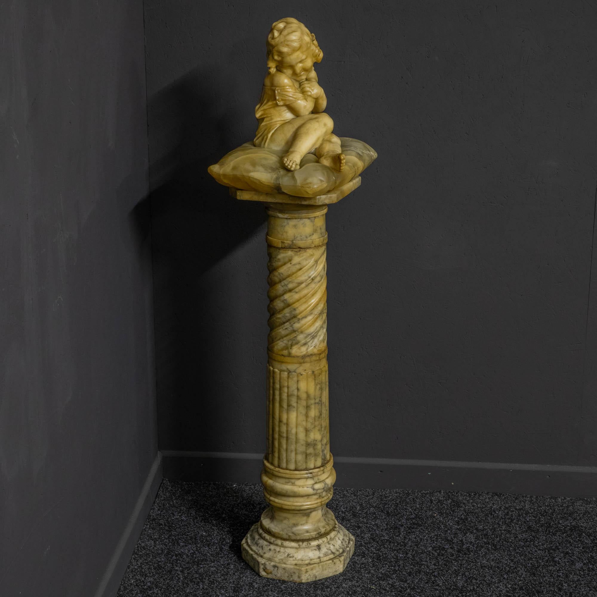 An attractive marble figure of a young girl posing in a rather coy manner seated on a grained marble cushion. The marble pedestal is octagonal at the base then turned on to fluting, into a spiral rising at the top. Whilst the marble figure has a