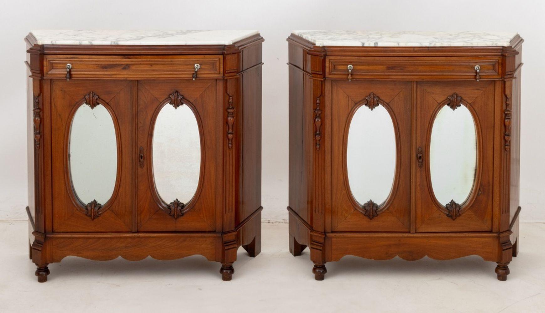 Paar viktorianische Nussbaum-Sideboards mit Marmorplatte, 20. Jahrhundert, jeweils mit Carrara-Marmorplatte über einer Fries-Schublade und einem zweitürigen Schrank mit ovalen Spiegeln, die sich zu zwei Regalen öffnen, mit geformter Schürze und