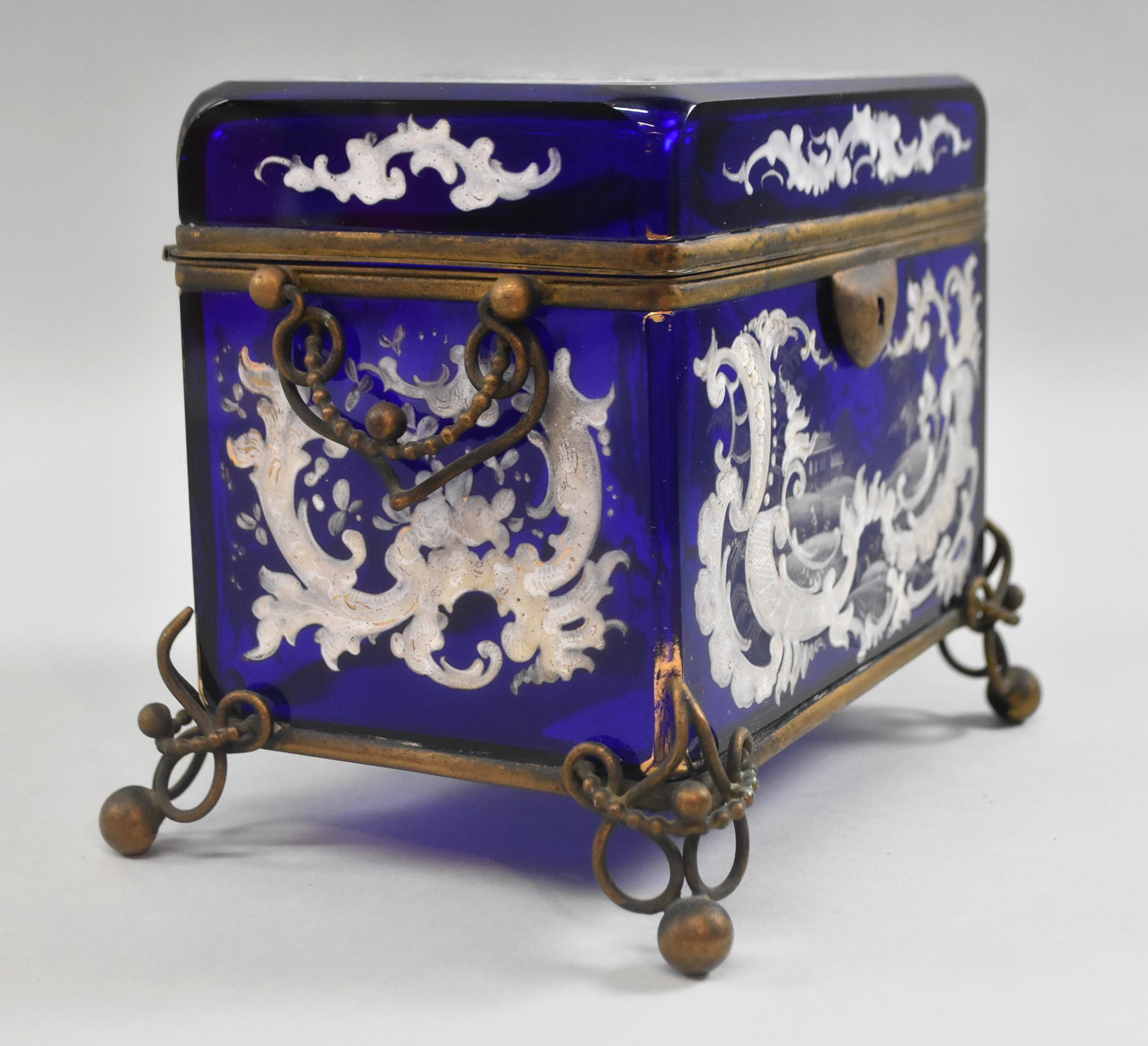A beautifully decorated antique Victorian cobalt blue jewelry casket / box. Three eights inch thick glass. Hand polished beveled glass edge wall. Heavy enamel paint. Elaborate brass metal work with two hinged handles. Very good condition. No chips