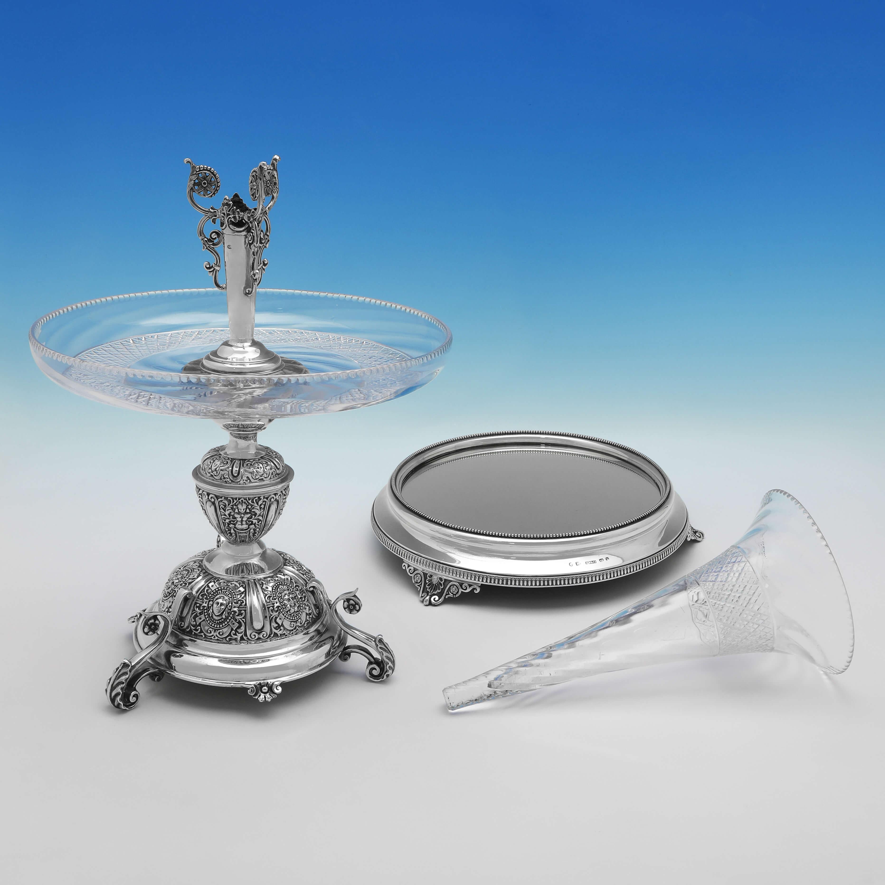Hallmarked in London in 1876 by Samuel Smily with the matching plateau hallmarked in Birmingham in 1876 by Horace Woodward & Co., this stunning, Victorian, Antique Sterling Silver Centrepiece, holds a glass vase and a glass dish, and features