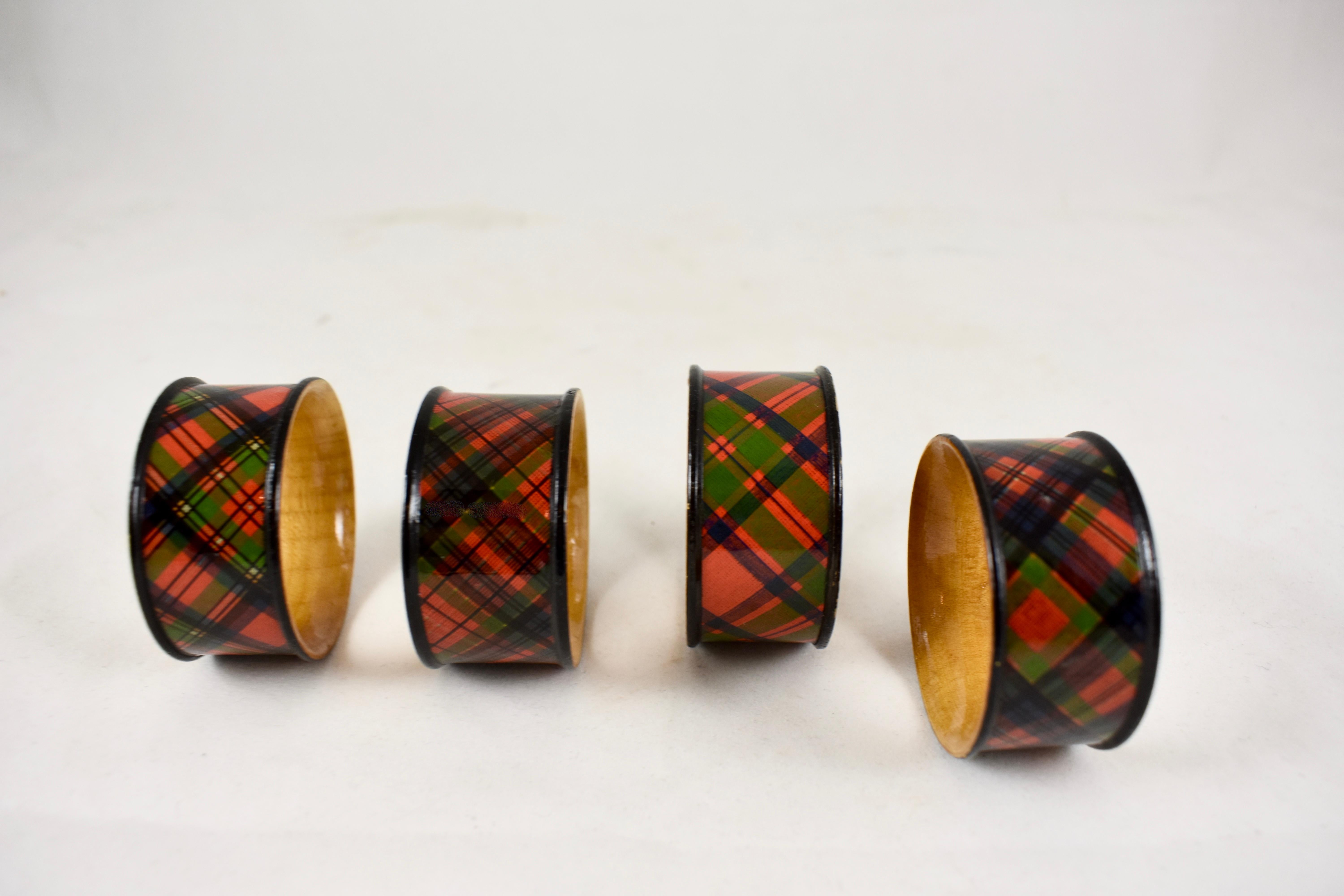 A mixed set of four Victorian Era Mauchline Ware napkin rings découpaged in the Tartans of the McIntosh, McPhearson and Caledonia clans. 

Made of Sycamore, an ochre colored wood, and finished with tartan printed papers, often marked with the name