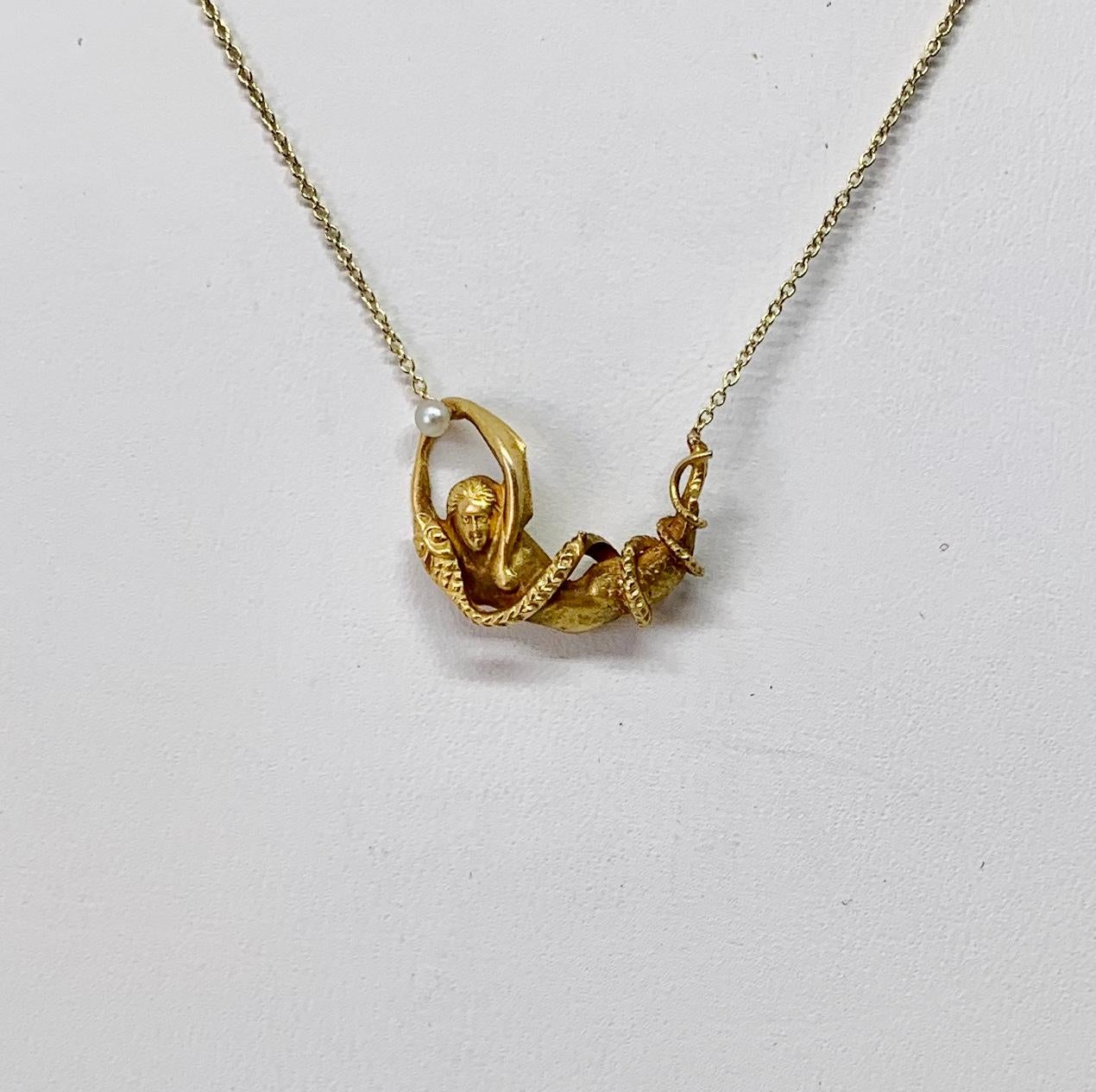 This is a rare antique Victorian Mermaid and Snake Pendant Necklace depicting a snake or serpent wrapped around a mermaid holding a pearl in her hand.  This is extraordinary imagery in this antique jewel that is over 100 years old.  Mermaids