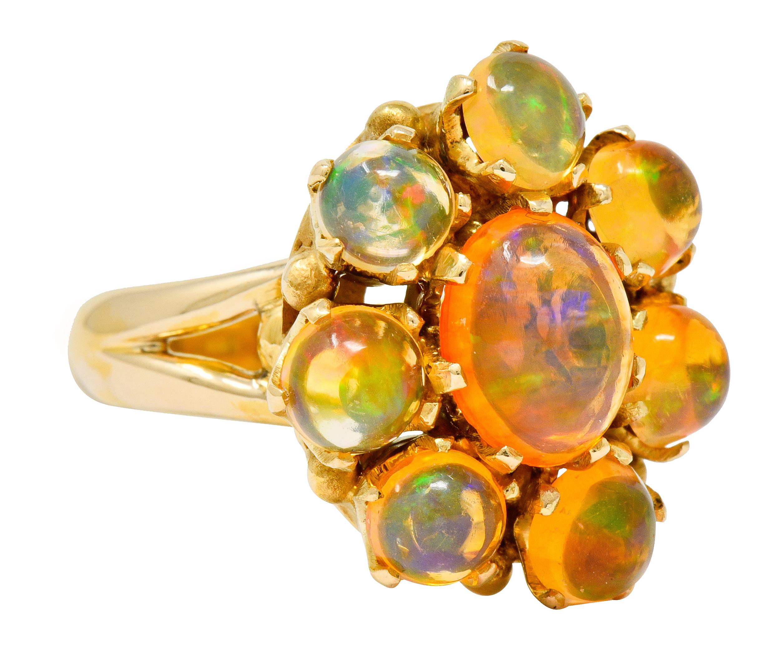 Cluster style ring centering an oval cabochon of Mexican fire opal measuring approximately 9.0 x 7.0 mm

Surrounded by 5.0 mm round Mexican fire opal cabochon

All well-matched with very light to light transparent orange body color and displaying