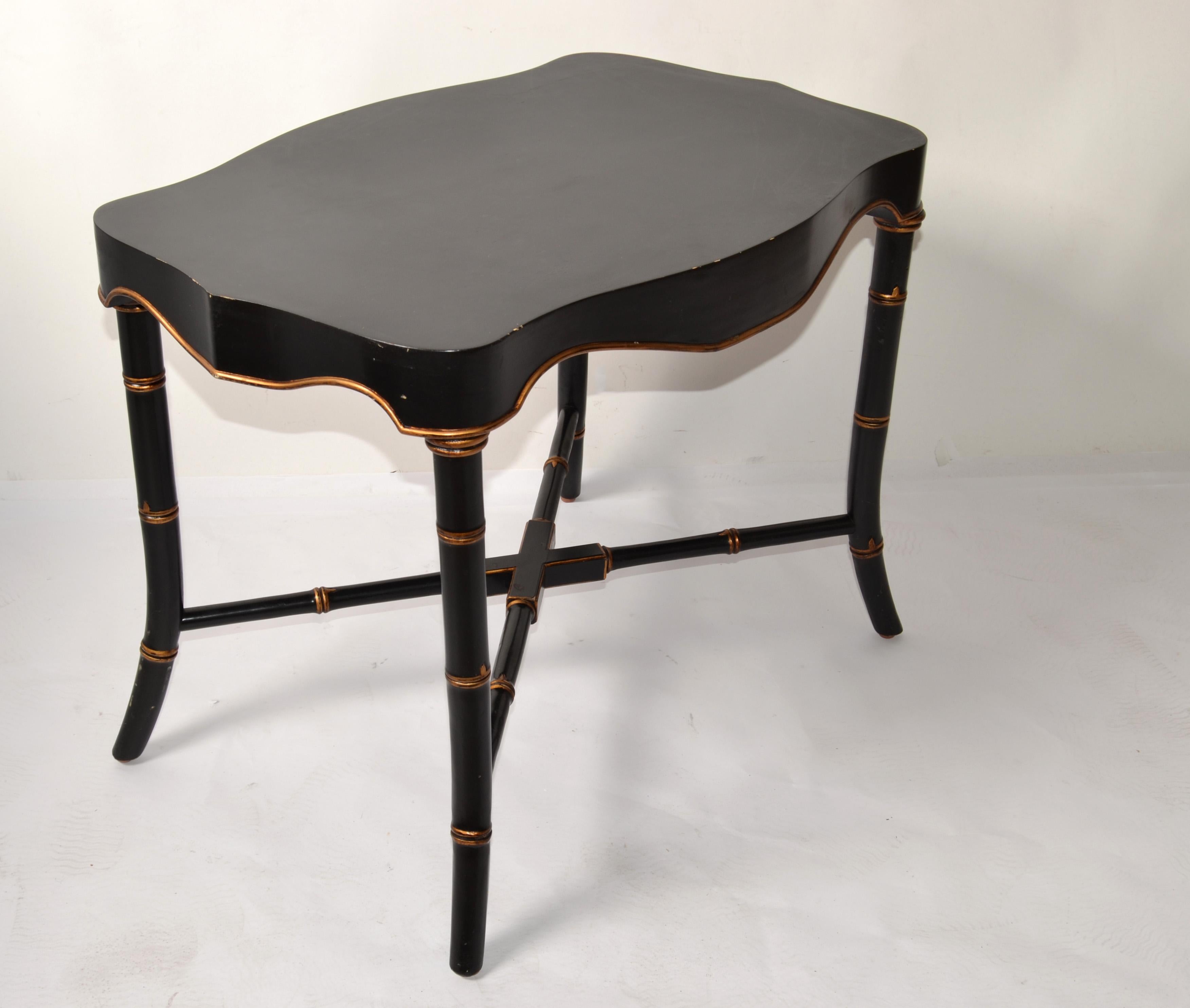 Mid 20th Century Victorian Style Black and Gold Finish Chinoiserie inspired Accent Table.
Featuring a rectangle carved Top with Apron and having four faux bamboo legs and cross stretchers. 
The slender Design is great for Side, End or Drink Table