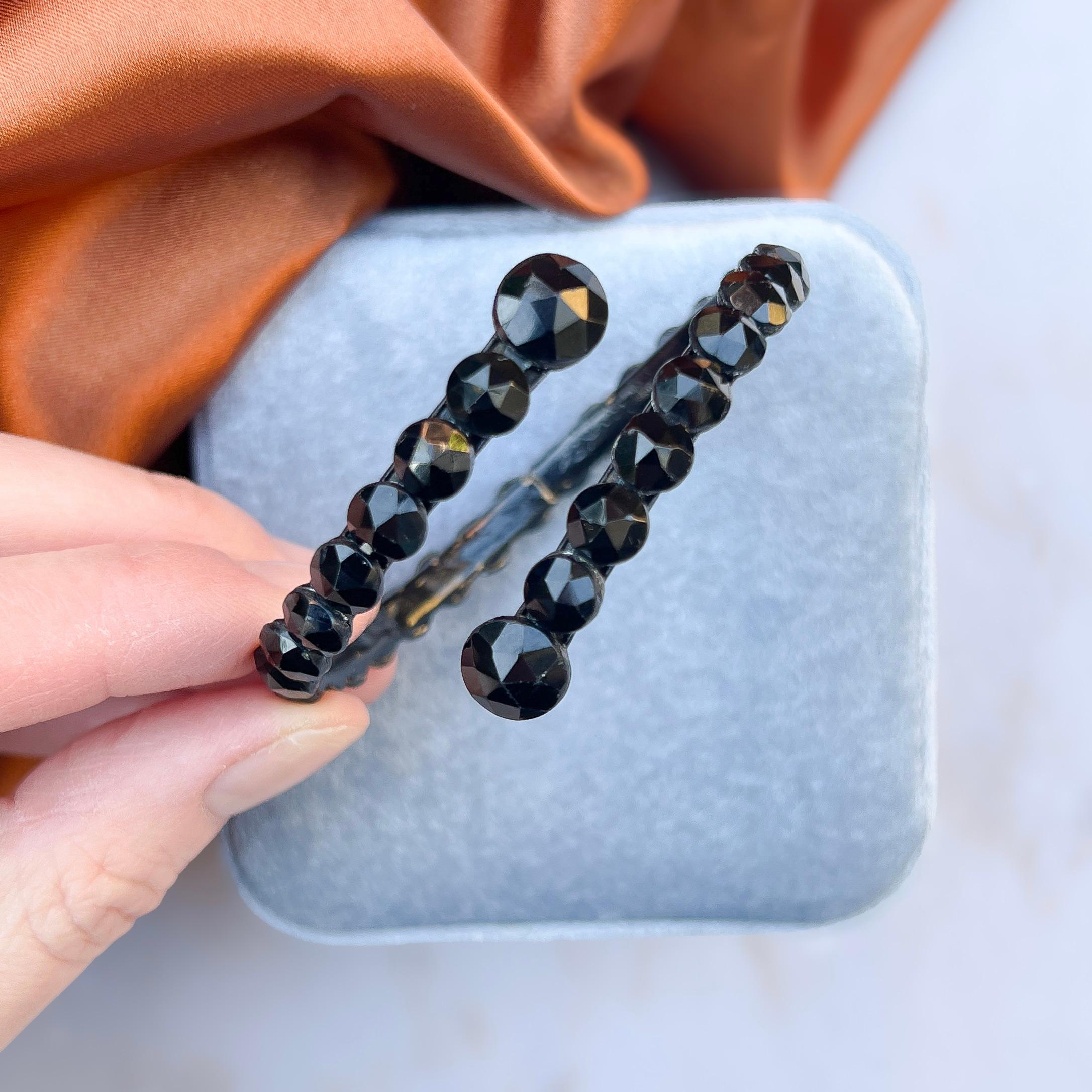 This stylish black glass bangle is an entirely original, elegant antiques. 

Condition Report:
Excellent 

The Details...
This bangle is constructed from sections of curved metal painted black and assembled to form a wraparound design. The bangle is