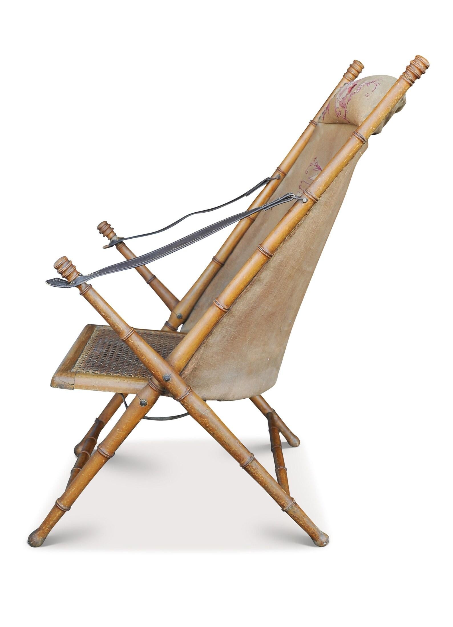 Ein feines Stück viktorianischer Militärkampagne. Ein Klappstuhl aus Bambusimitat, mit einer bestickten Sitzfläche aus Segeltuch auf der Rückseite, mit Armlehnen aus braunem Leder und einem gedrechselten Buchenholzrahmen 

Zusätzliche Abmessungen