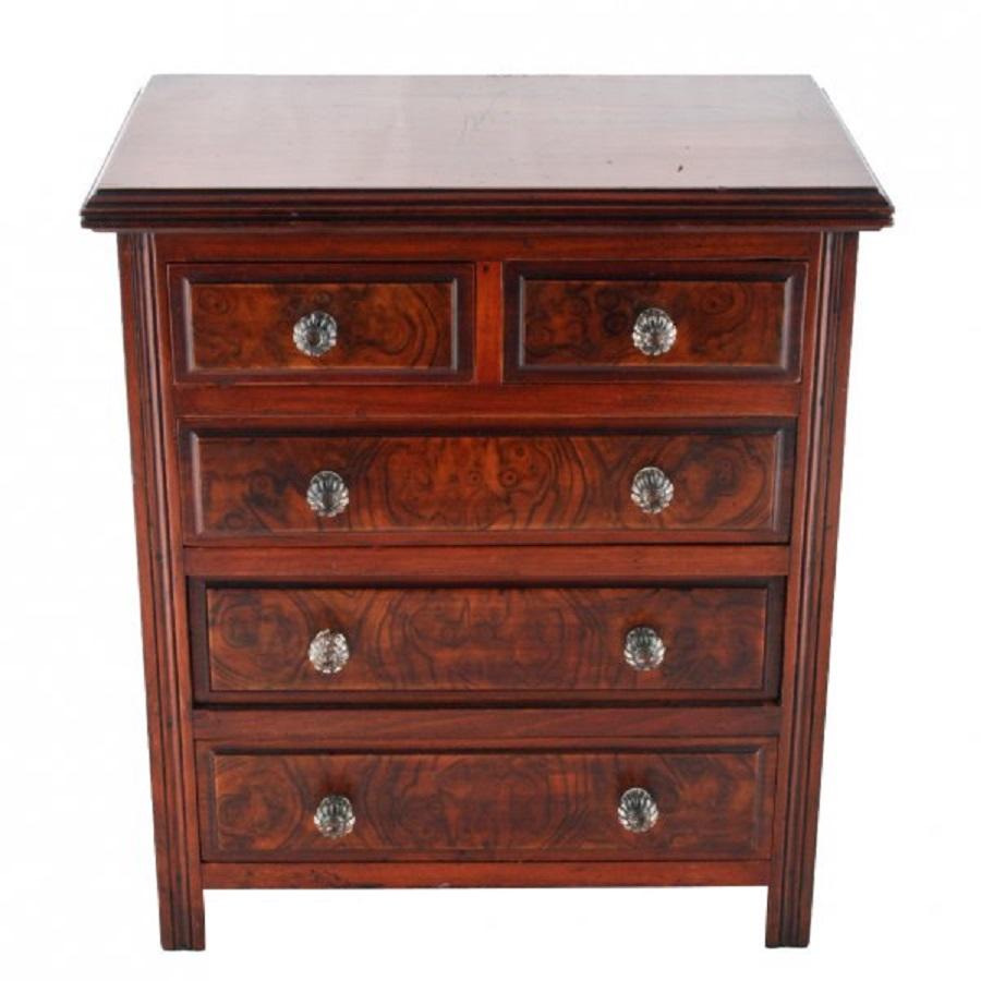 A late 19th century Victorian miniature walnut chest of drawers.

The chest has two short drawers over three long drawers with burr walnut veneer to the drawer fronts and moulded glass knob handles.

The drawers are pine lined and the chest has