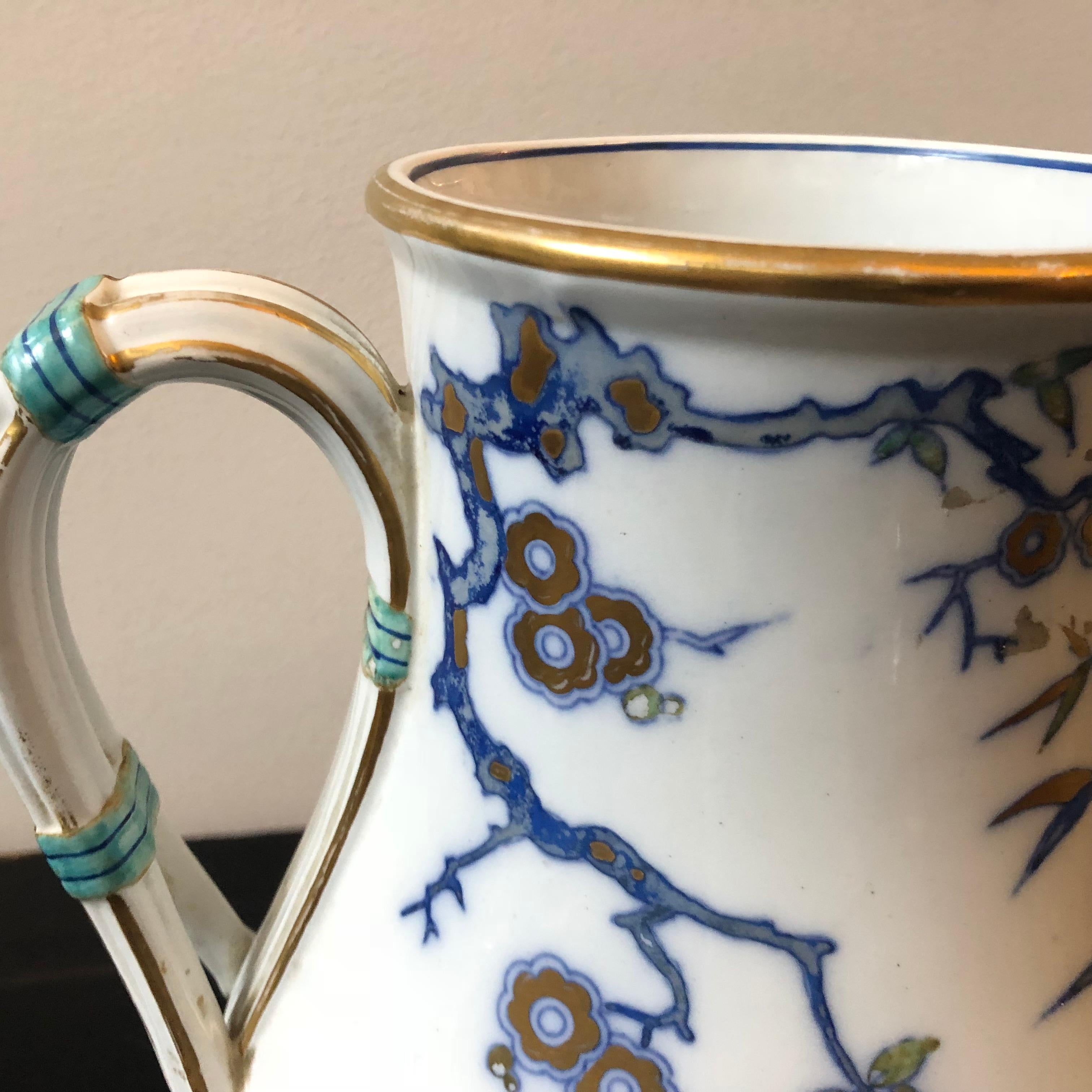 An Aesthetic Movement Minton pitcher decorated with blue and gold oriental flowers on a white ground. The bottom is in a basket weave pattern. The underside has the Victorian registration mark.
 