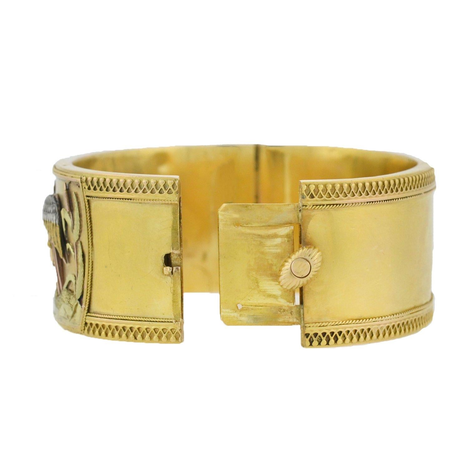A particularly stunning and unusual aesthetic movement bracelet from the Victorian (ca1880) era! This lovely bangle is crafted in vibrant 15kt yellow gold and features an incredible aesthetic movement design that graces the front surface. The
