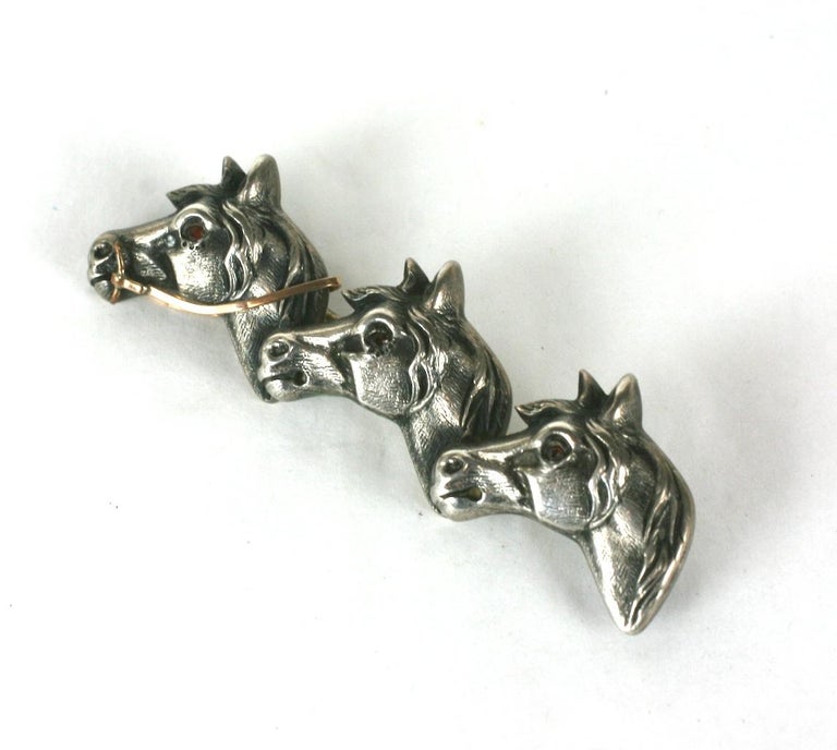 Victorian mixed metal brooch of Race Horses running neck to neck. Of sterling silver, the lead horse's bridle of gold filled metal with garnet paste eyes. 1880's USA. 
Excellent Condition
Length 2.50