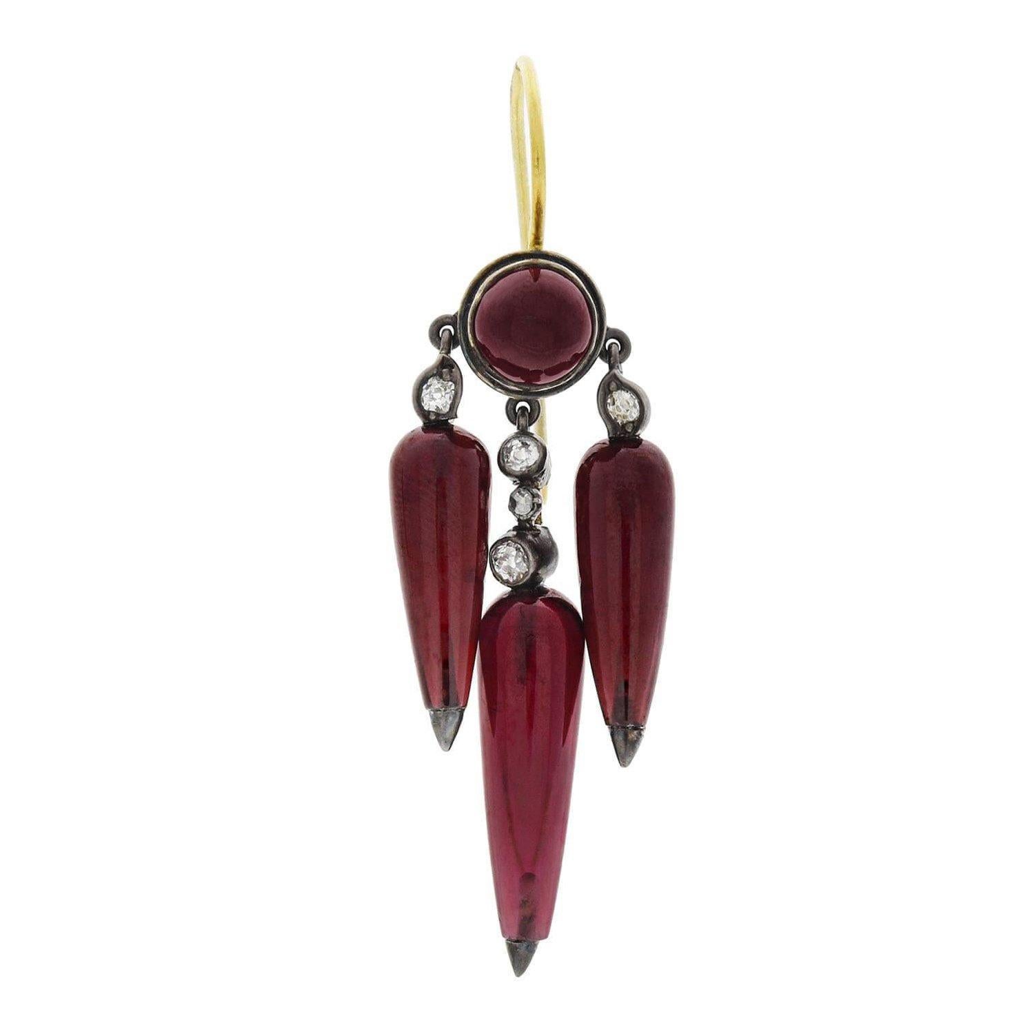 A rare and highly unusual pair of earrings from the Victorian (ca1880) era! Crafted in 14kt gold and topped in sterling silver, each earring displays rich garnets and sparkling diamonds to form an incredible and elaborate hanging design. Three