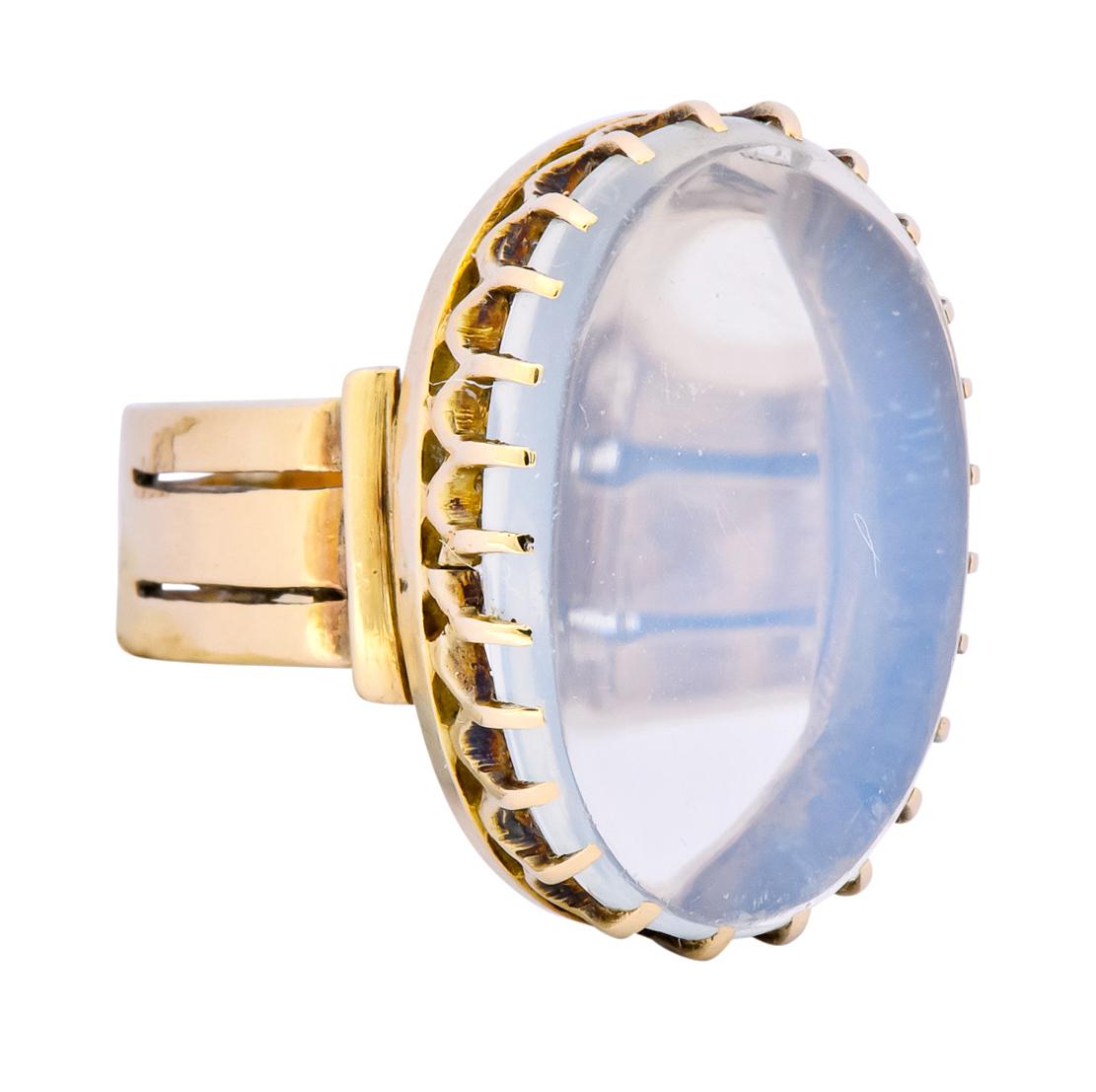 Centering an oval cabochon moonstone measuring approximately 7/8 inch x 9/16 inch, transparent with slight white adularescence

Claw set into an oval mounting accompanied by a wide shank with pierced striations

Tested as 14 karat gold

Ring Size: 5