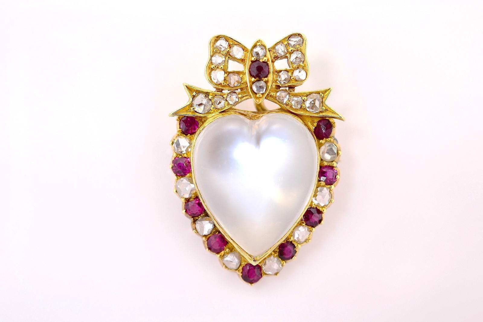 The 1890's brings us this hand created one-of-a kind gorgeous Moonstone bauble, both a brooch and pendant.  A beautiful heart-shaped bluish Moonstone is bezel-set in an 18KT yellow gold frame.  An encrusted bow sits atop and Rose cut Diamonds and