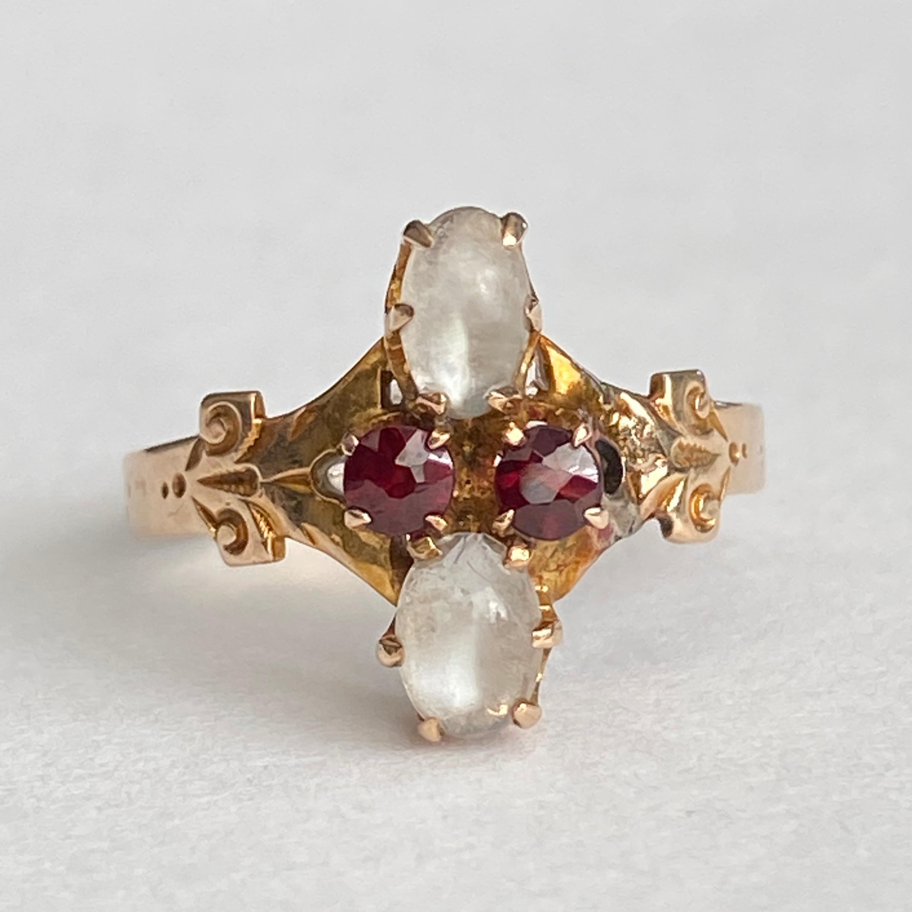 Details:
Super sweet Victorian ring with moonstones and garnets. The ring is 14K rose gold, and has a lovely engraved pattern sounding the setting. There are 2—5mm x 3mm cabochon moonstones, and 2—2.5mm red garnets. Please ask all necessary